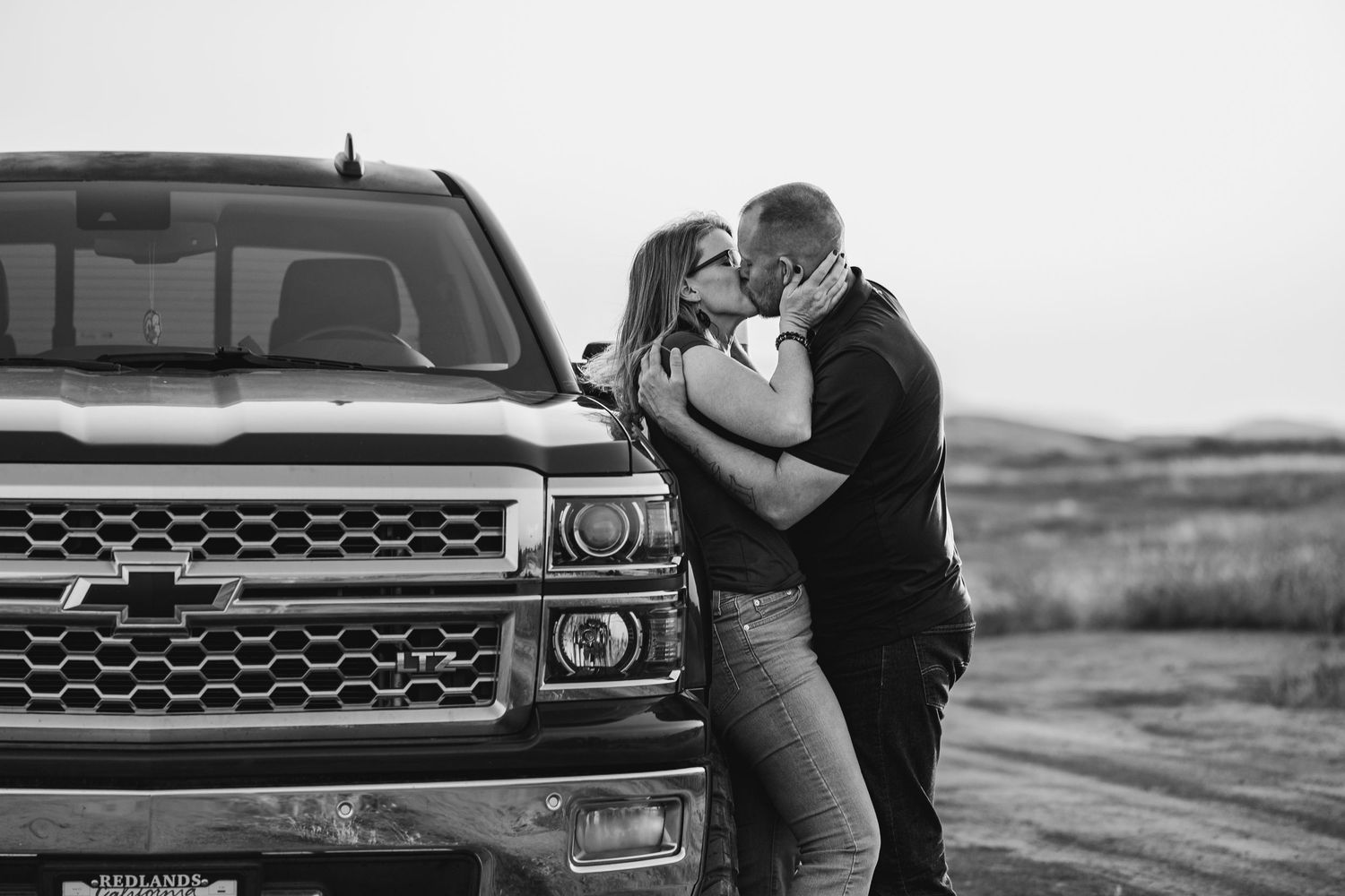Classic pickup truck parked on a rugged dirt road during a dramatic black and white photo shoot.
