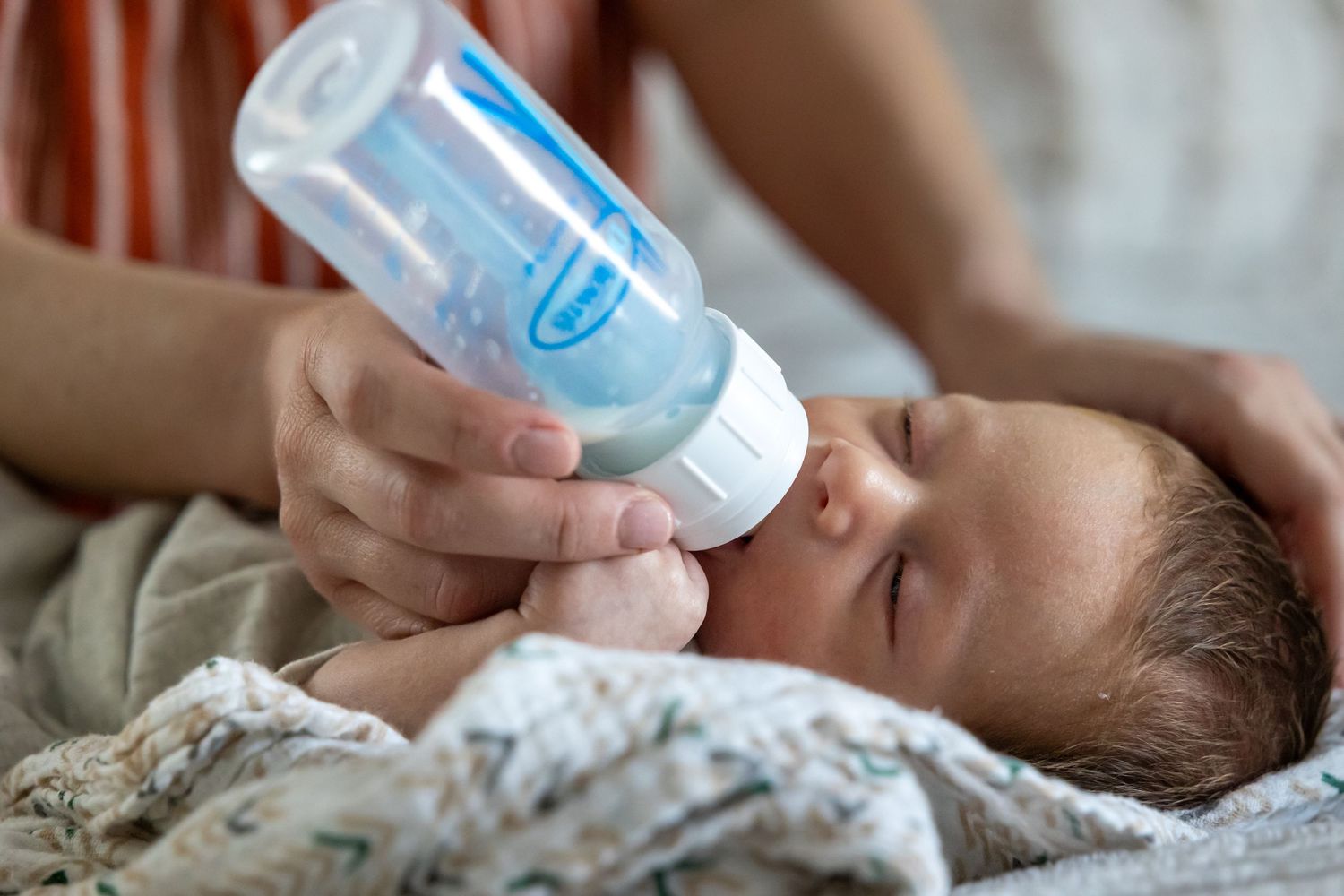 A baby bottle feeding moment captured in natural light.
