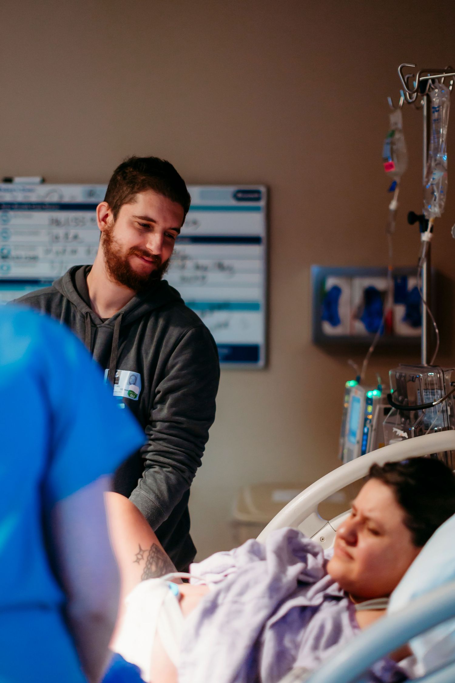 Hospital room scene with medical equipment and supportive care during labor.