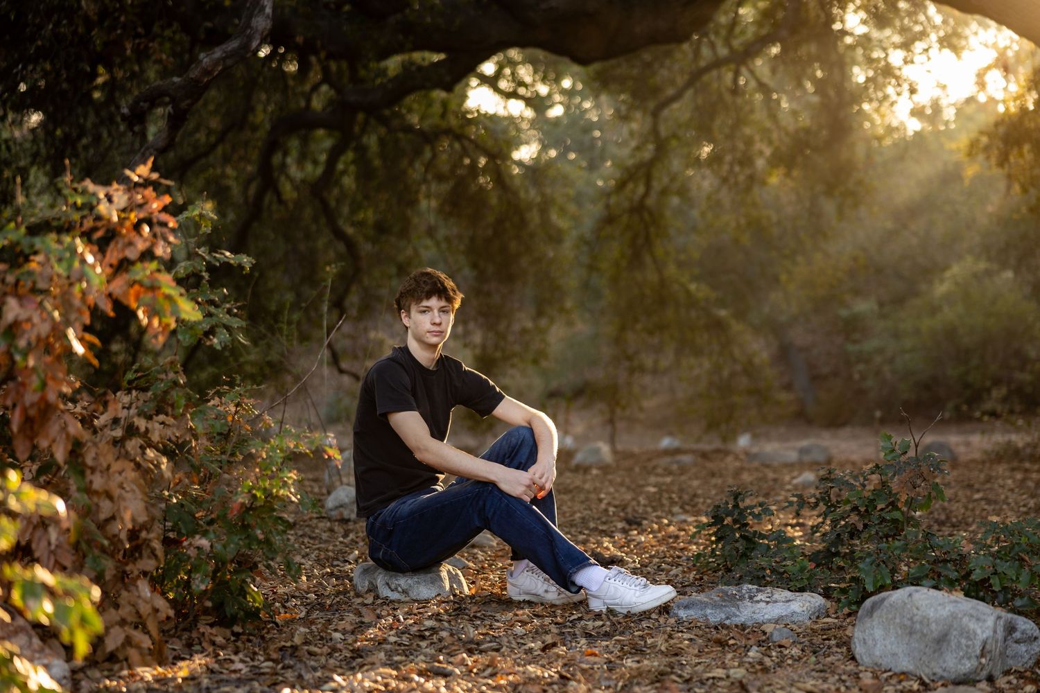 Natural light portrait session amid trees and rocks during golden hour in Claremont at the botanical gardens.