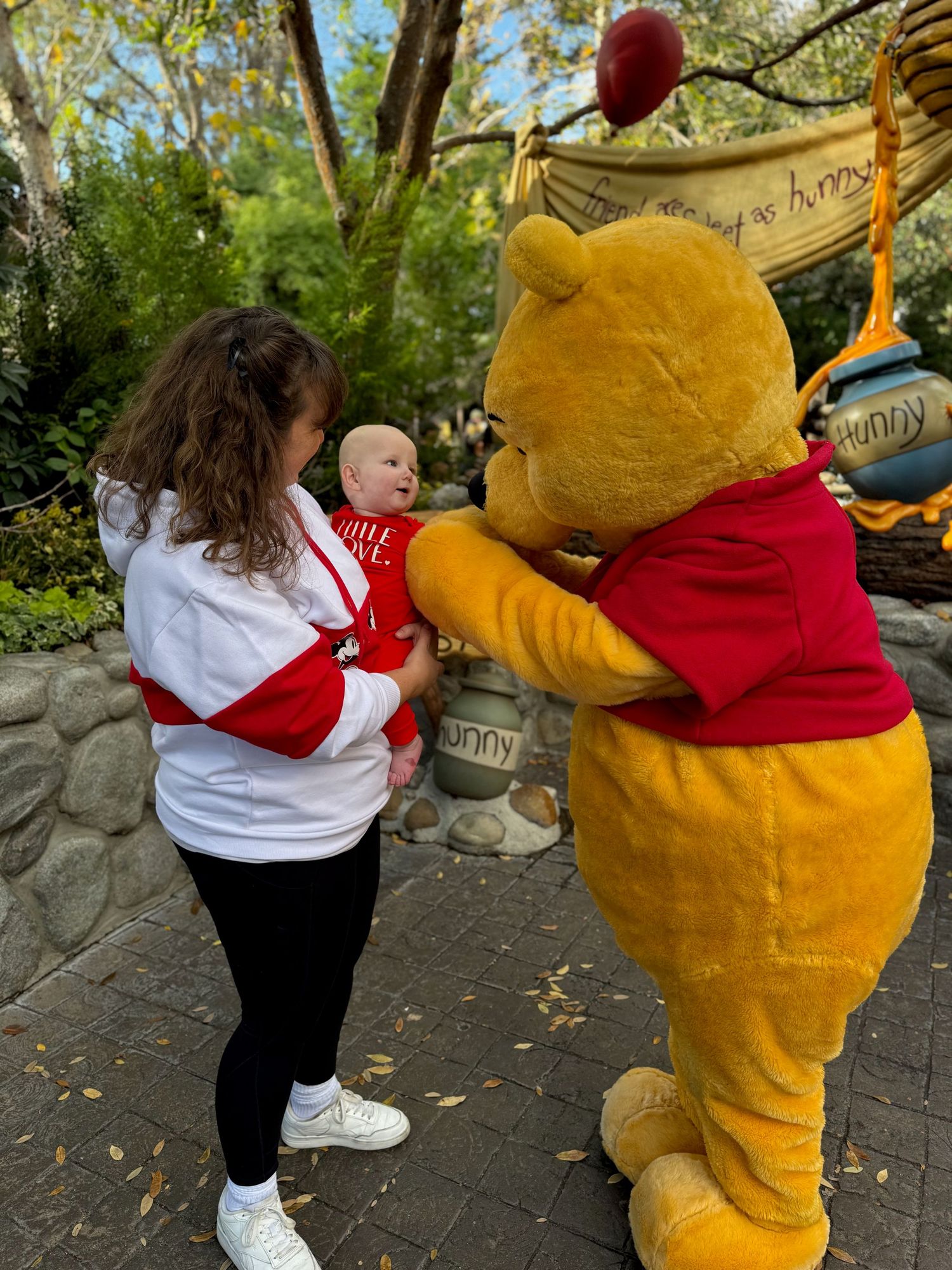 Small child interacting with large yellow costumed character in an outdoor setting.