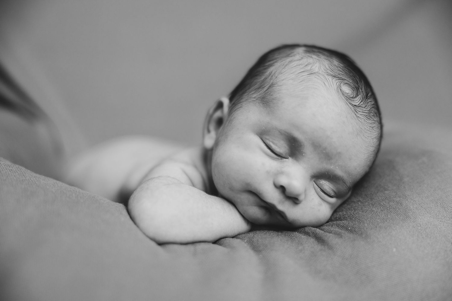 Peaceful sleeping newborn in black and white portrait style.