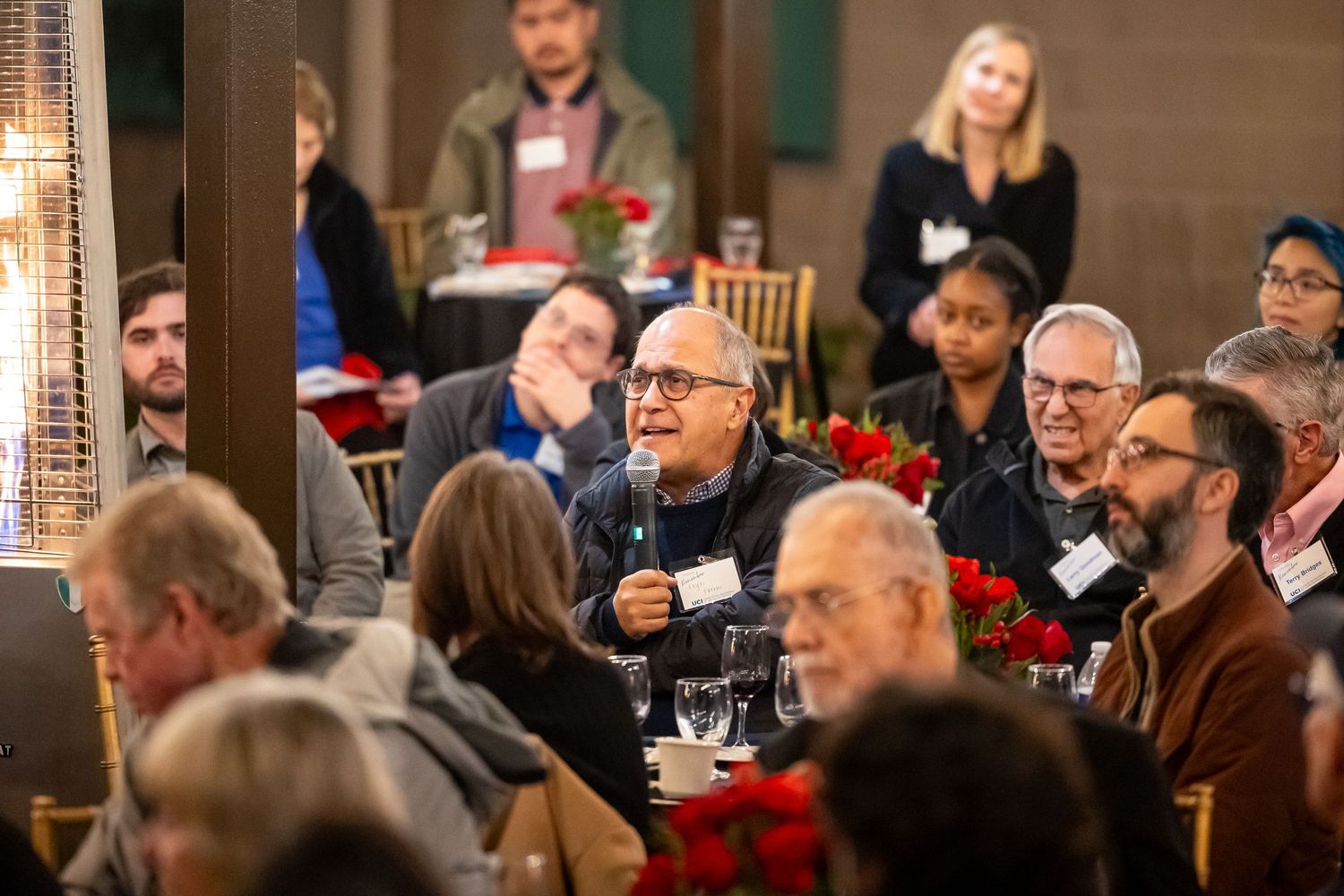 People sitting at tables during a conference or networking event in an indoor venue.