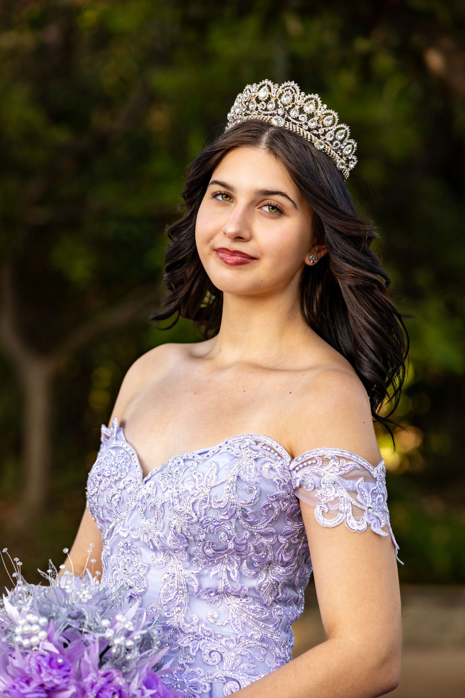 Quince in lavender dress with ornate crown poses outdoors in a series of graceful portraits in Redlands.