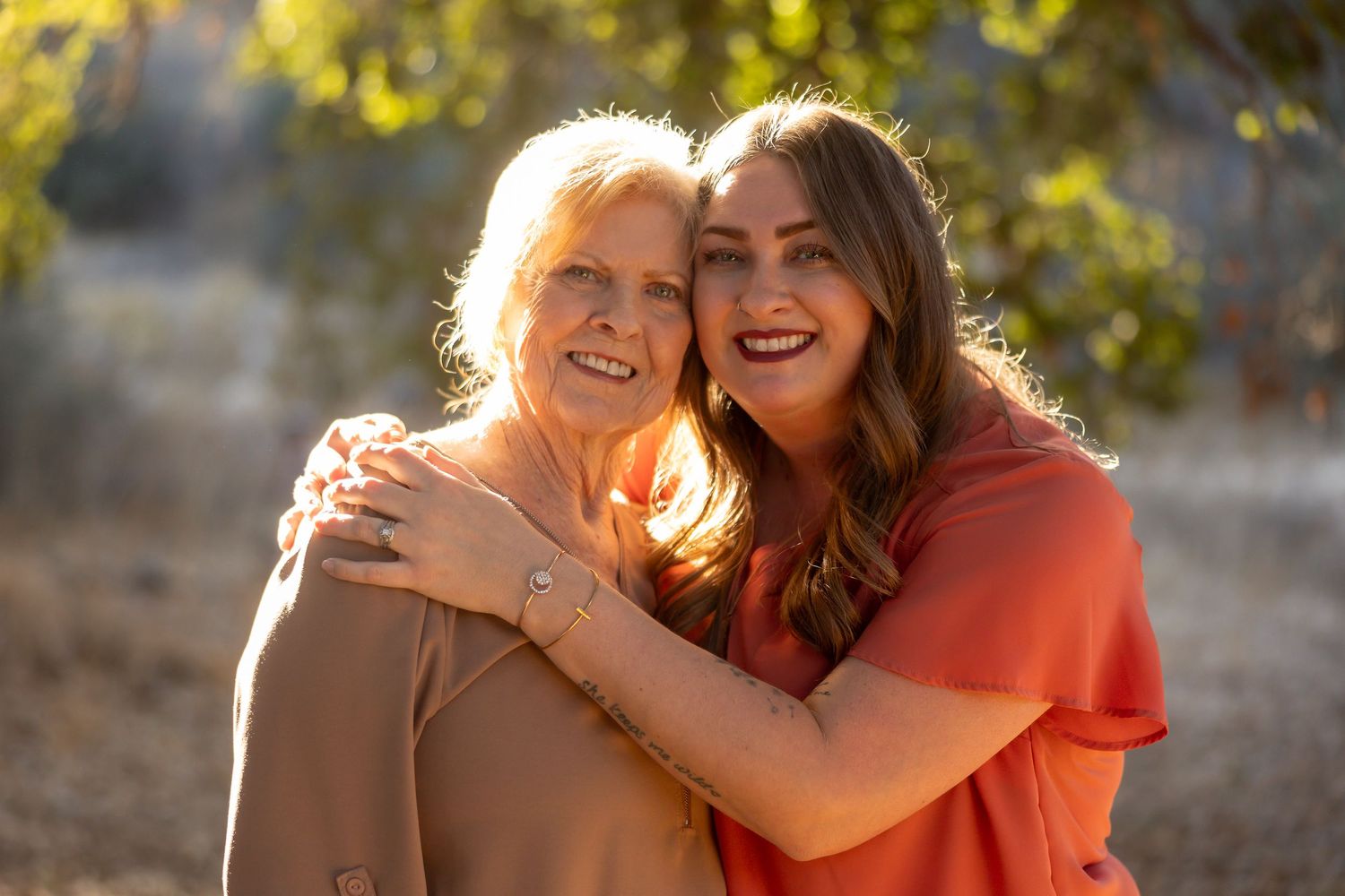 Family group embracing in warm autumn colors during golden hour photo session.