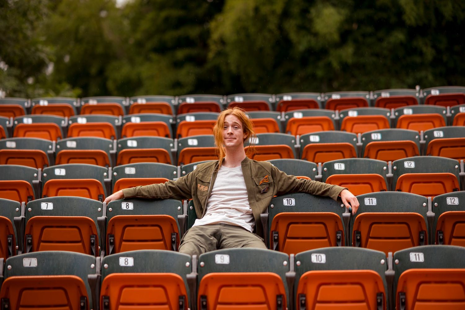 Empty orange stadium seats provide unique backdrop for casual outdoor portrait in Redlands.