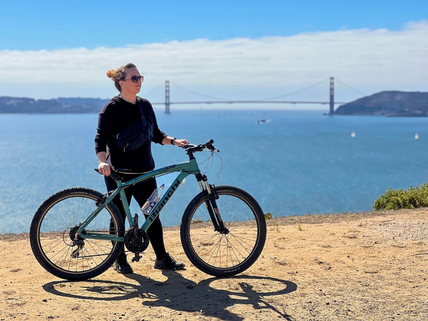 Hilary poses with her bike against the stunning backdrop of the Golden Gate Bridge and San Francisco Bay.
