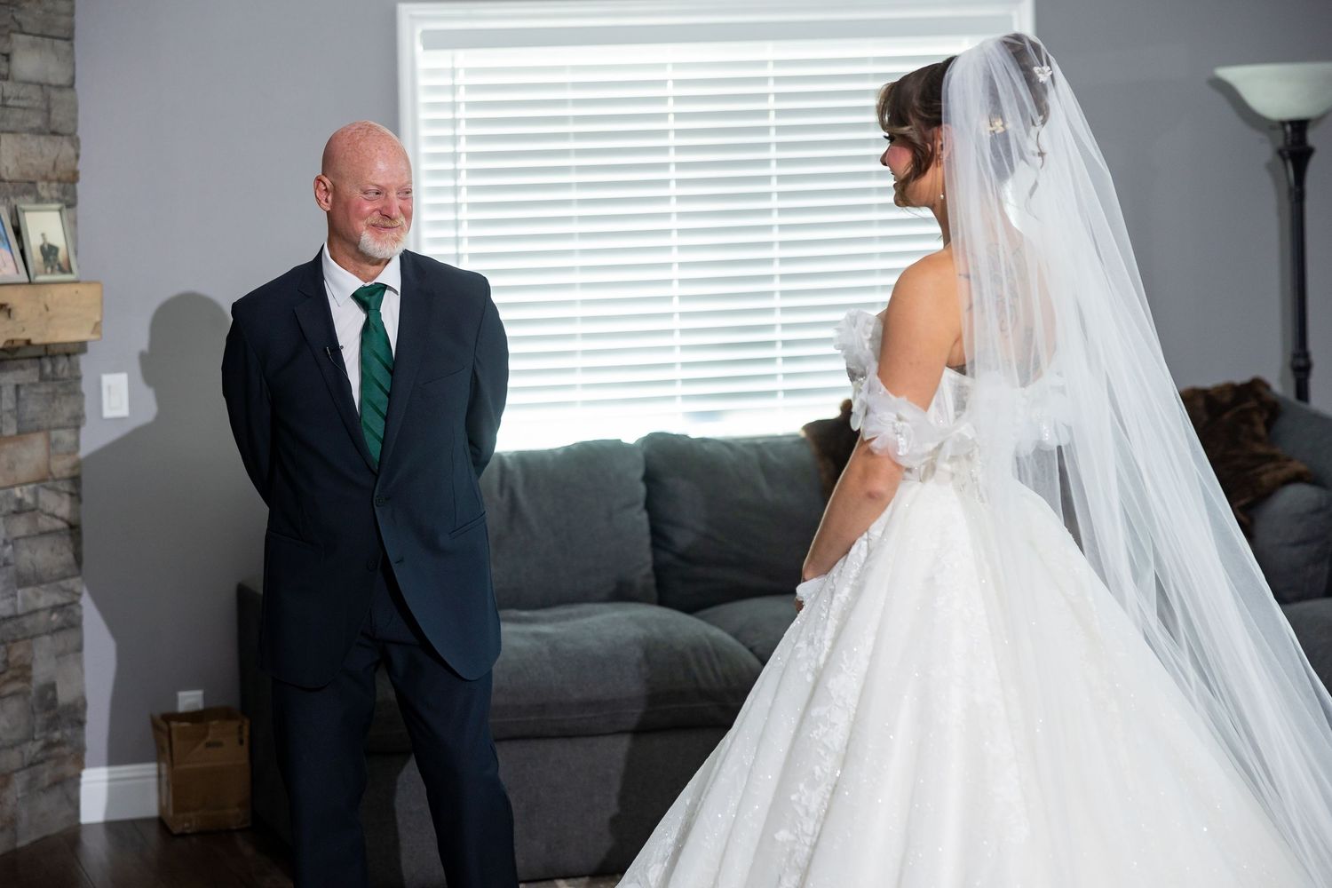 Emotional wedding day moments captured in an indoor setting with stone accent wall.