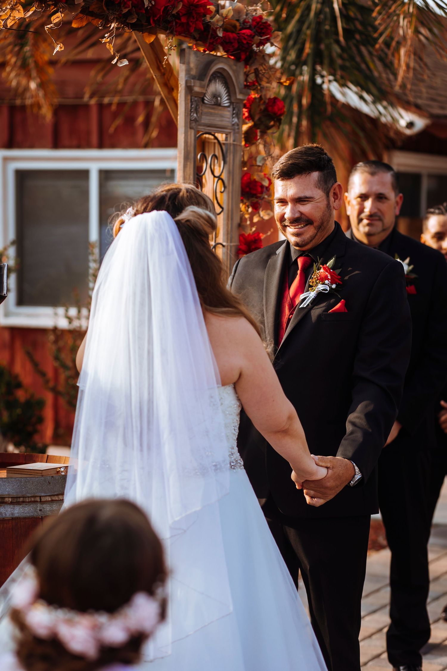 Wedding ceremony under rustic arch with autumn flowers and vintage decor.