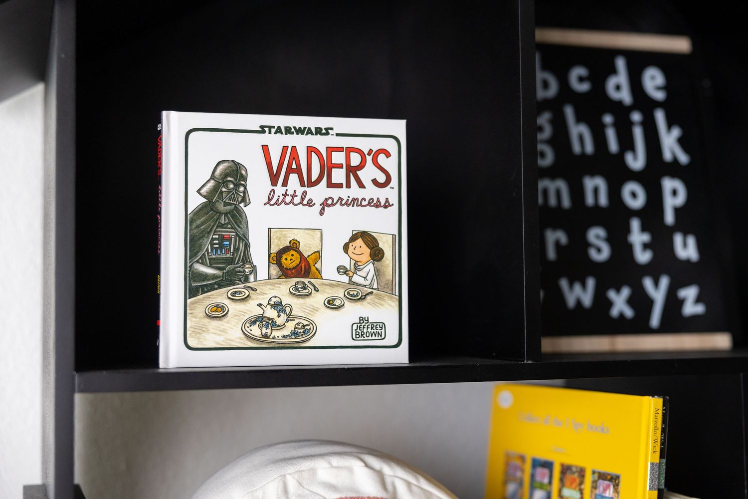 Nursery setting with Star Wars decor and alphabet letters visible on dark walls.