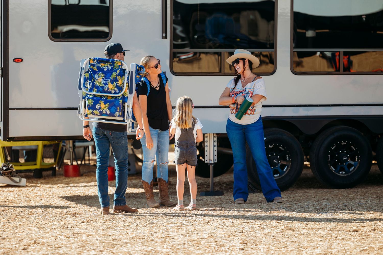 Group gathering outside an RV at a desert campground.