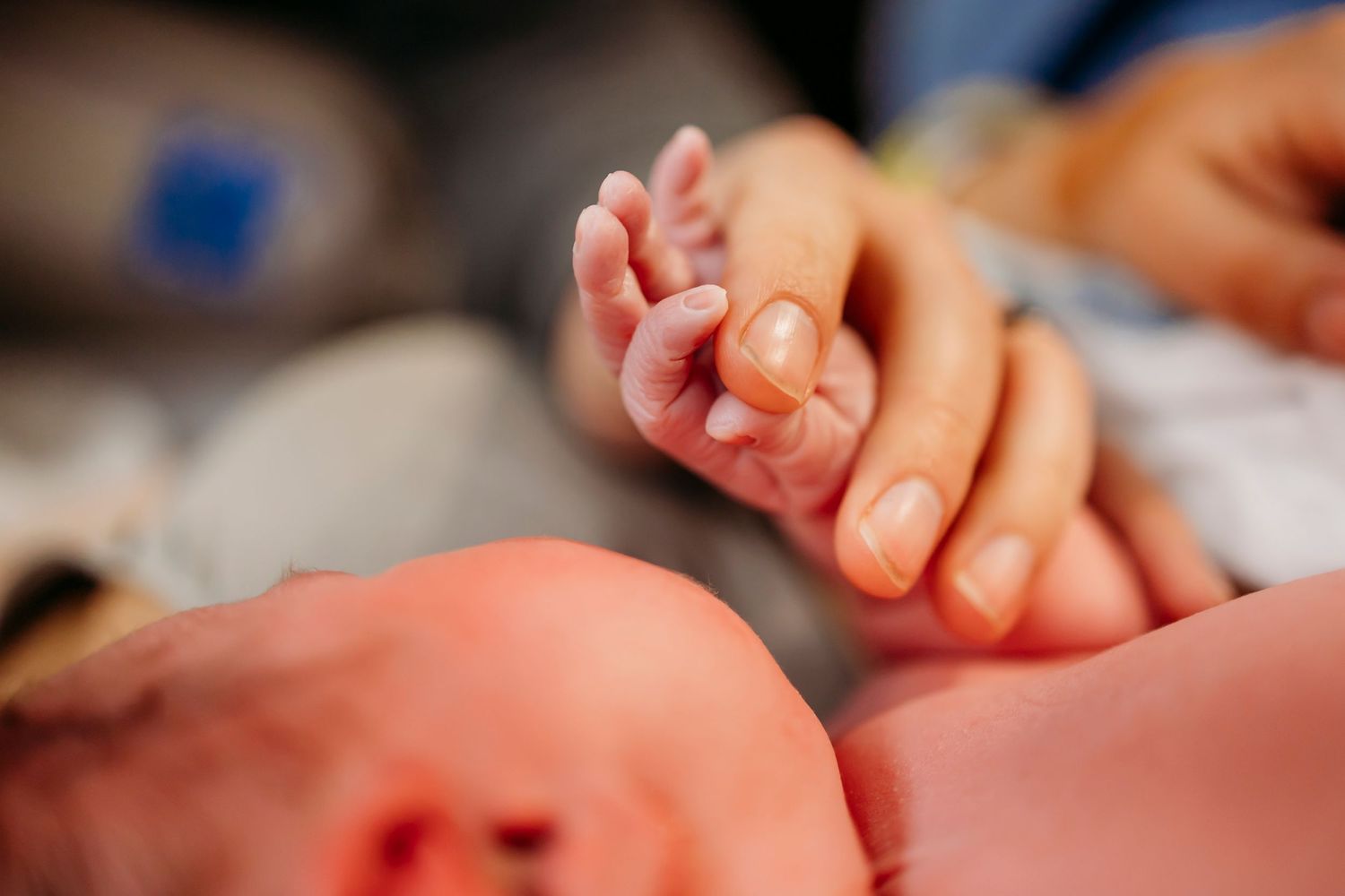 Close-up details of hands and medical equipment during childbirth.