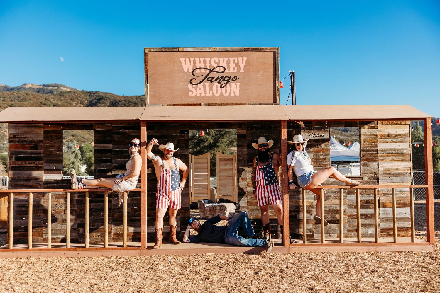 Wide view of rustic western-style buildings and storefronts at outdoor festival.