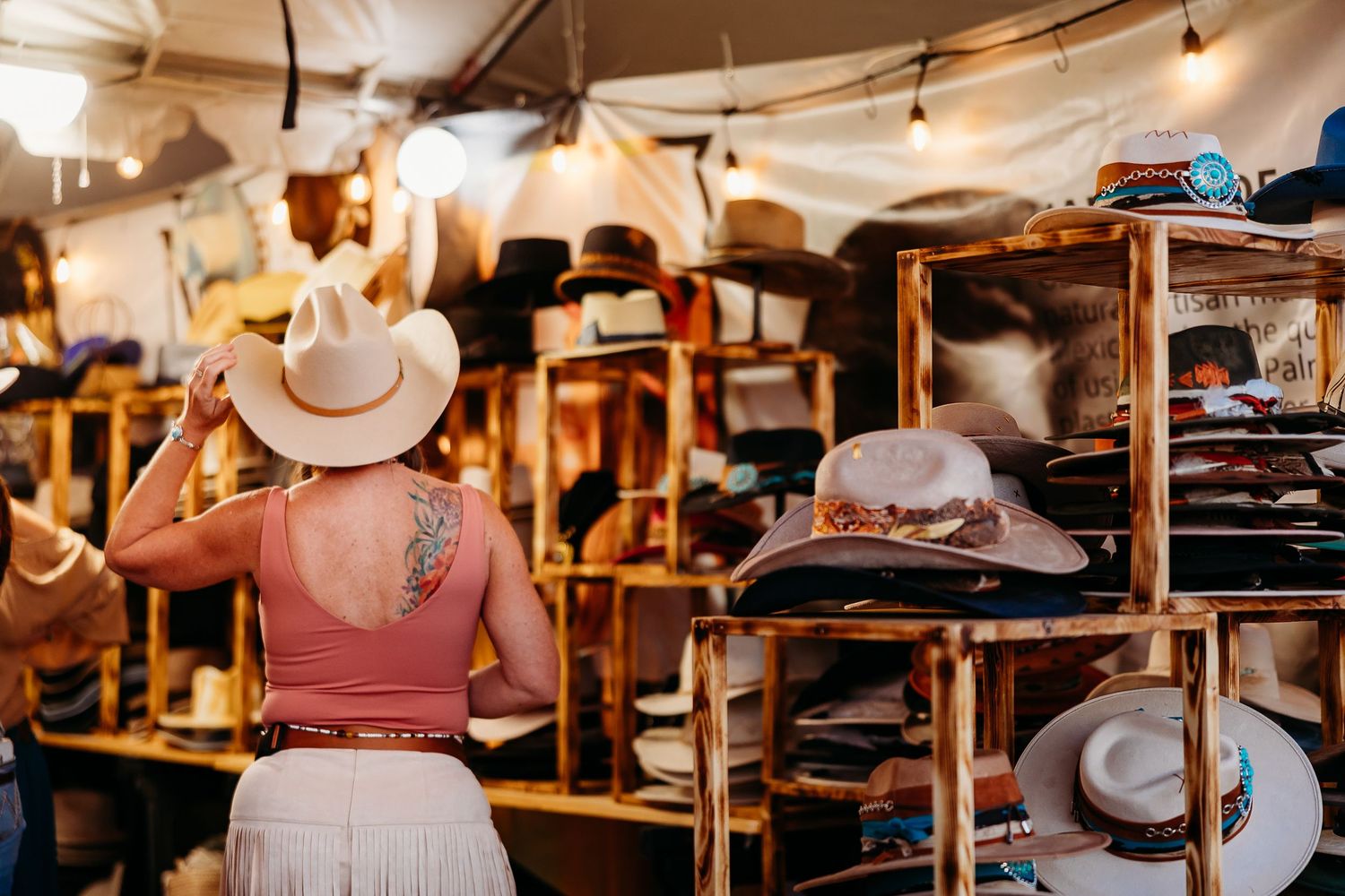 Western hat display inside a rustic clothing store with cowboy hats arranged on shelves.
