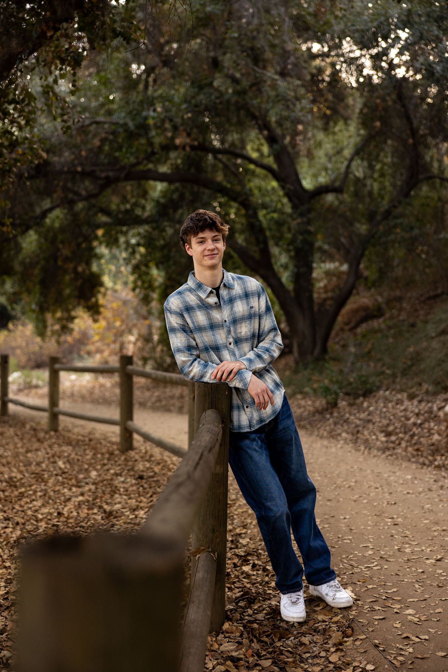 Casual outdoor portrait session in a wooded park with fallen autumn leaves in Claremont at the botanical gardens.
