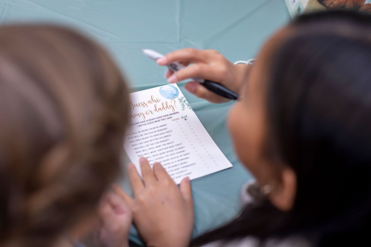 Group of guests playing party games with paper and pens at an event.