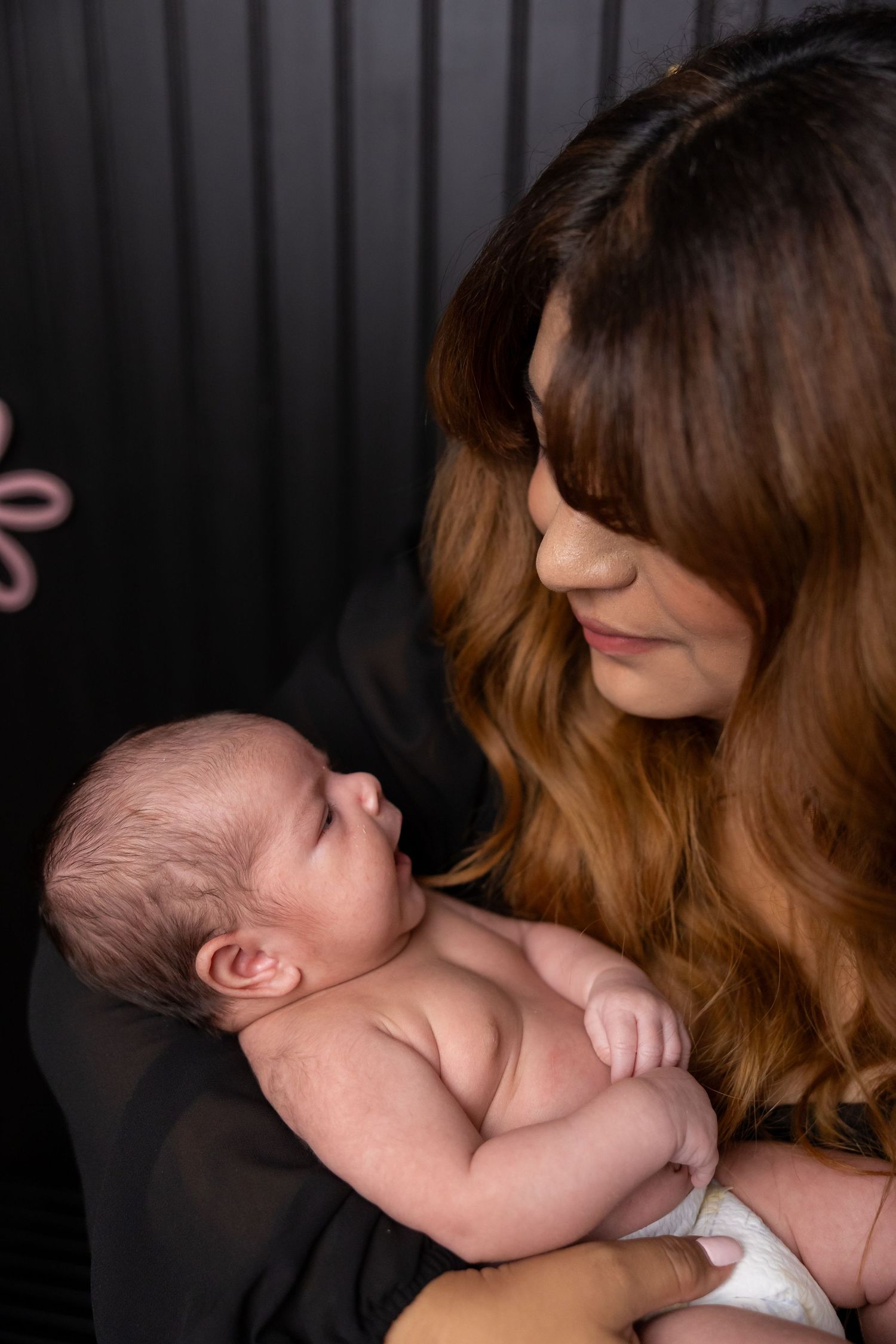 Tender moment of newborn resting peacefully in caring embrace.