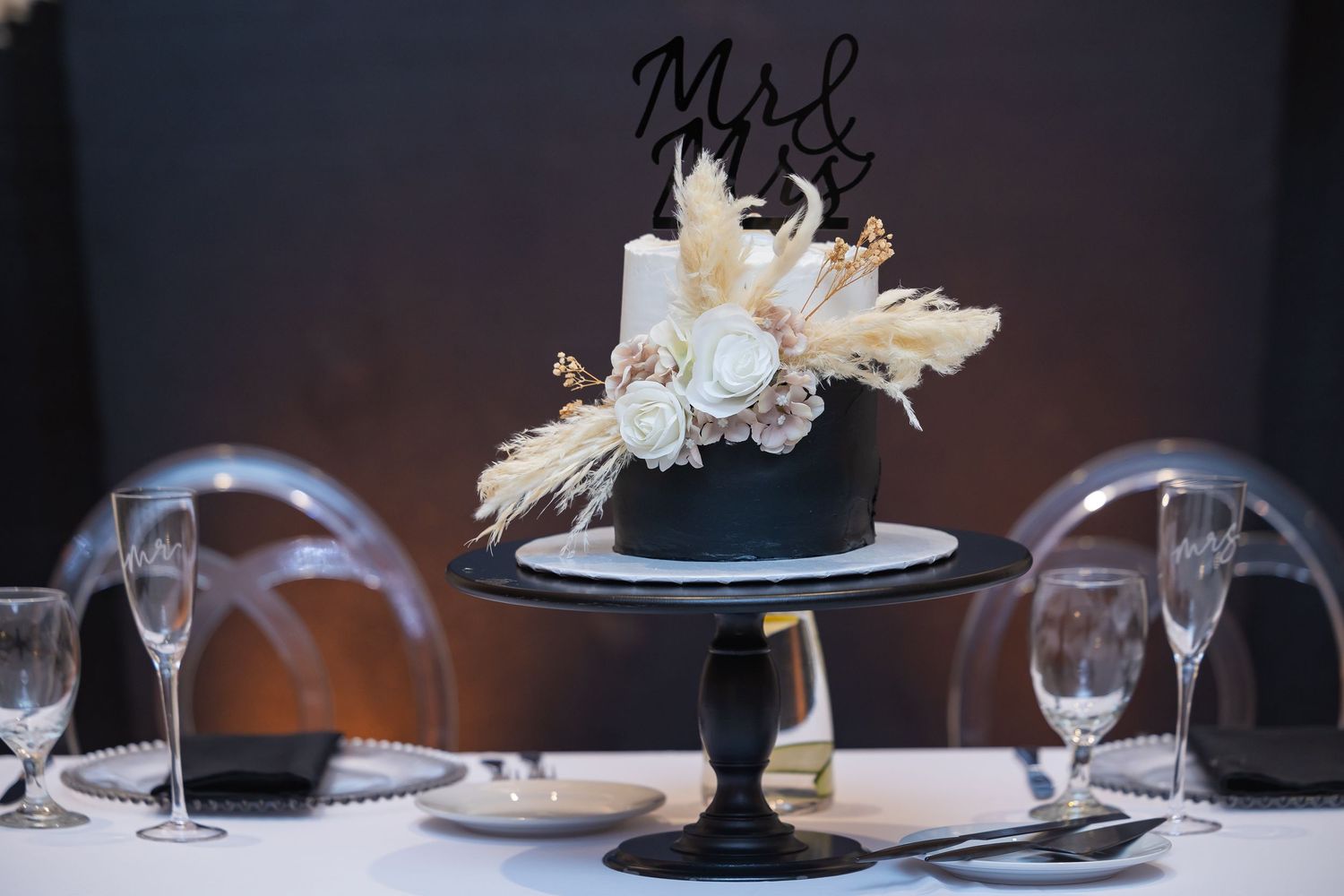Formal table settings with wine glasses and menu cards at an elegant wedding reception.