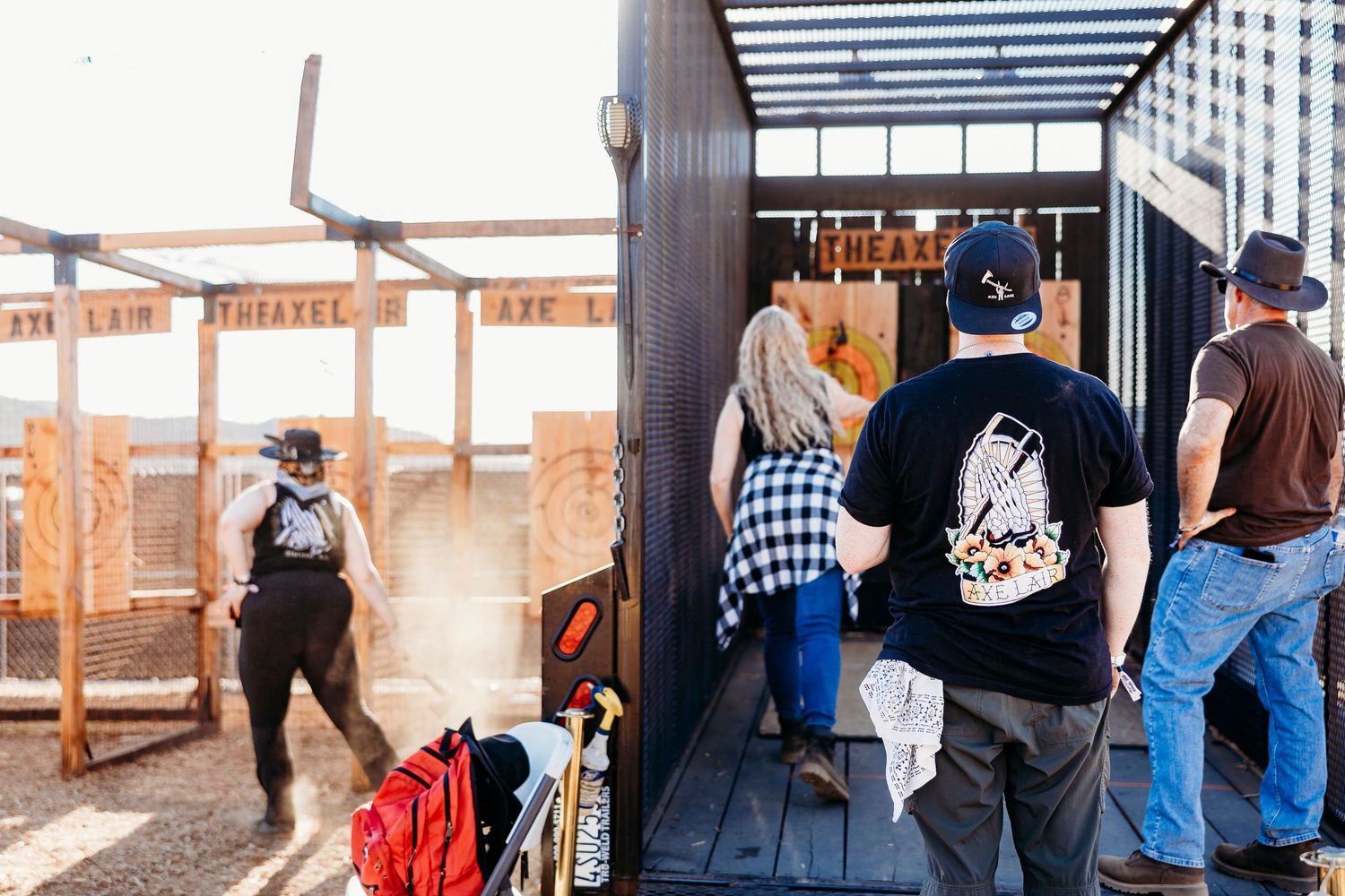 Festival attendees gathering under wooden structures at western-themed event.