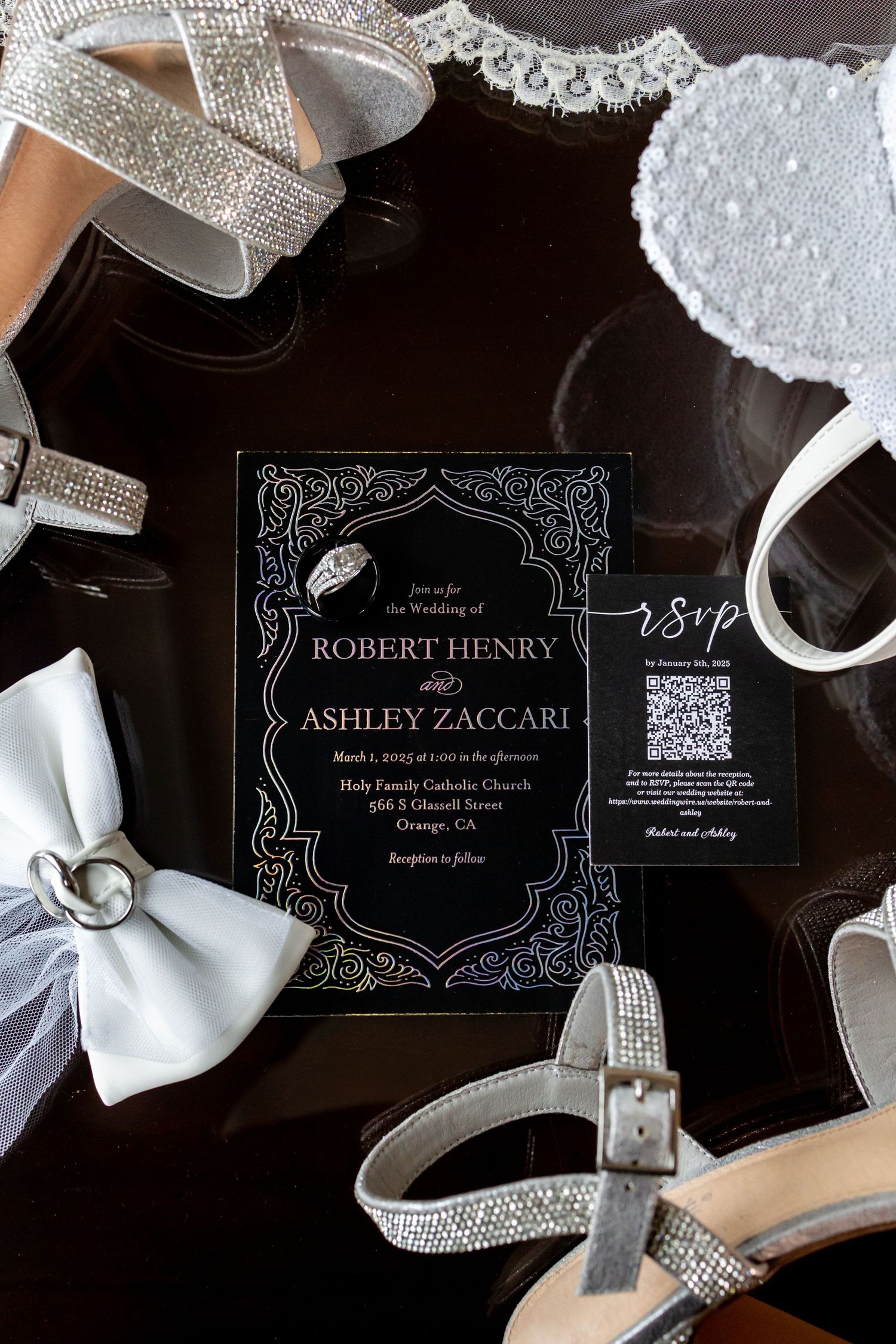 Black and white wedding invitations with elegant typography and lace details displayed on a dark background.