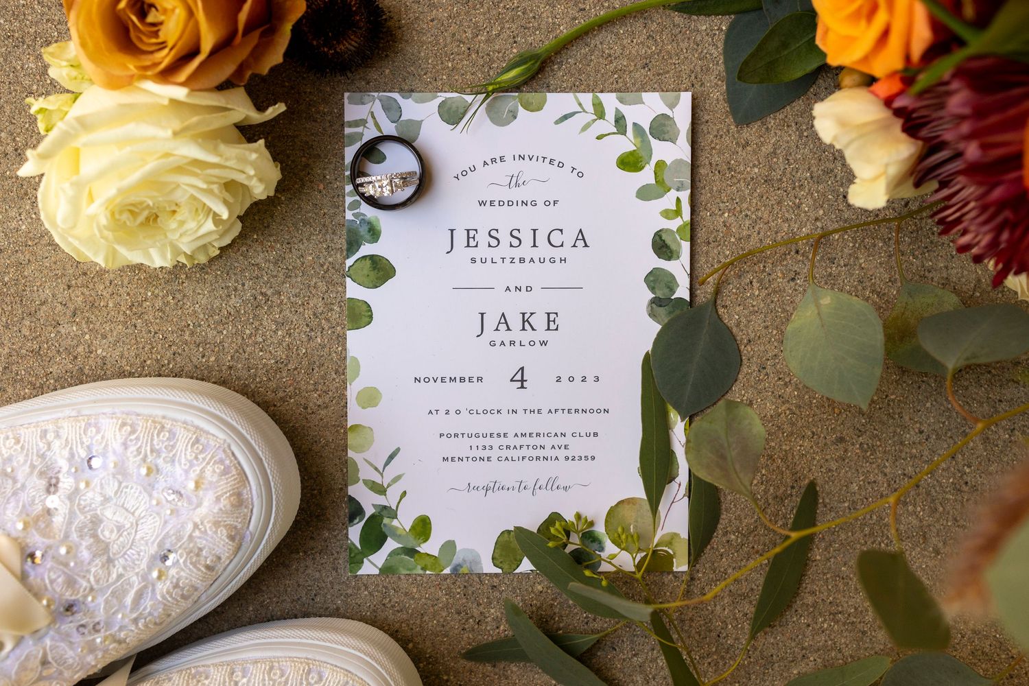 Wedding invitation suite with orange roses and delicate floral design elements.