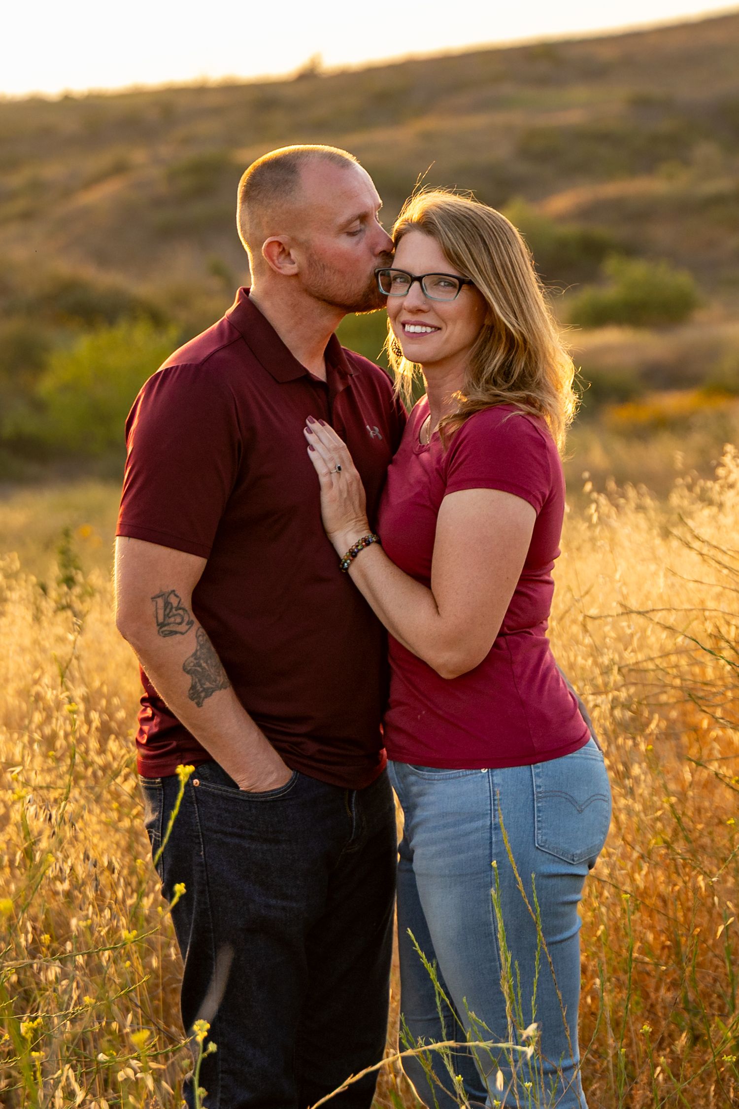 A romantic sunset photoshoot in a golden field with soft natural lighting.