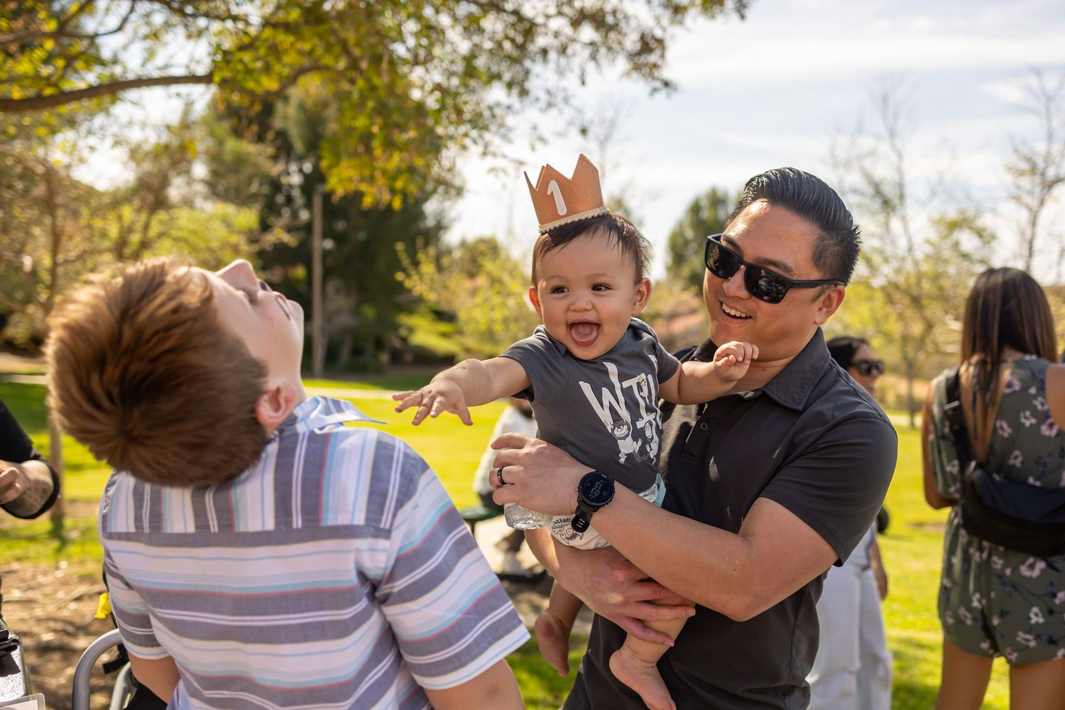 Joyful outdoor celebration with small child wearing party crown.