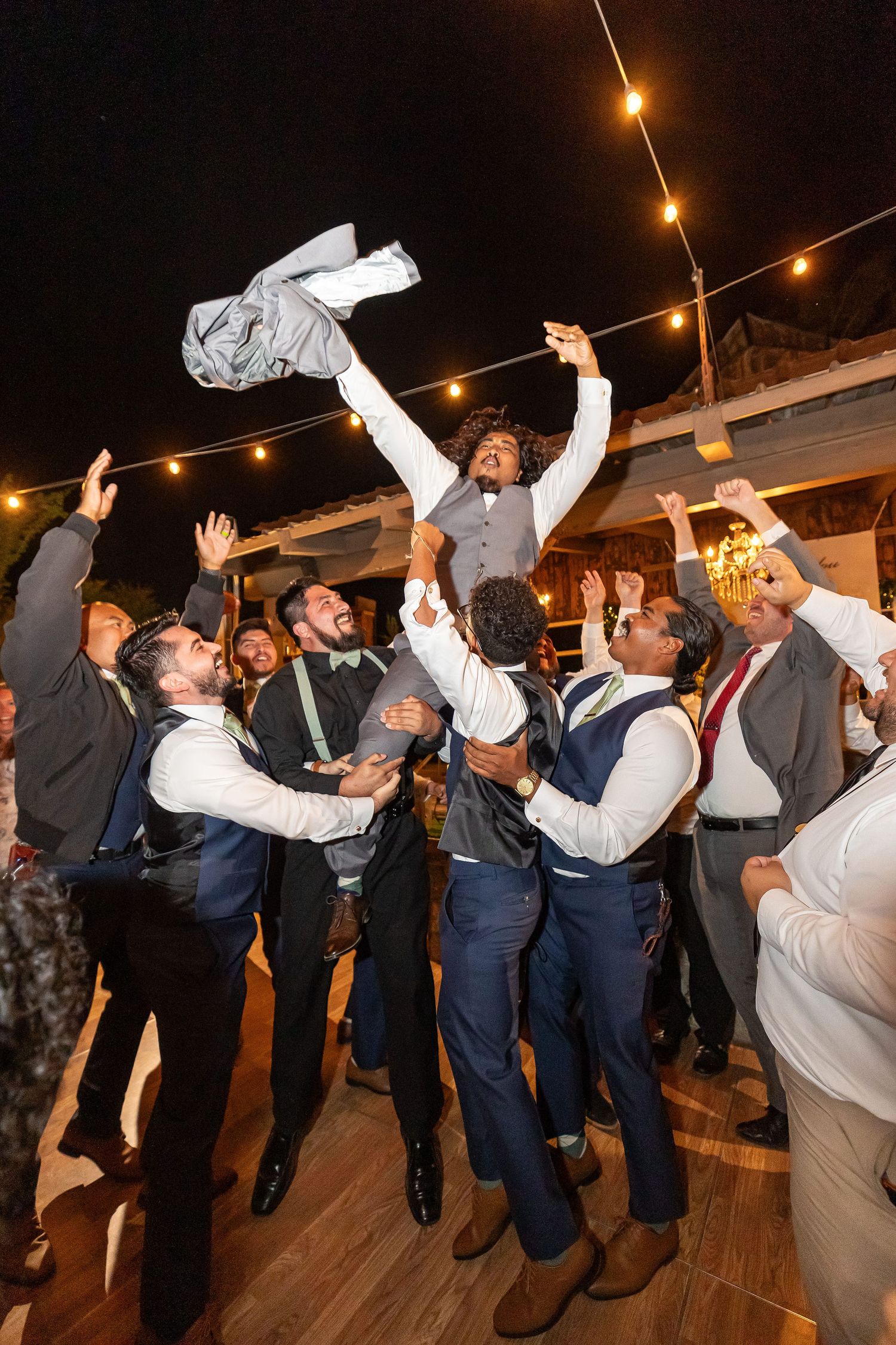 A celebration on a dance floor lifting up the groom during the reception in Oak Glen