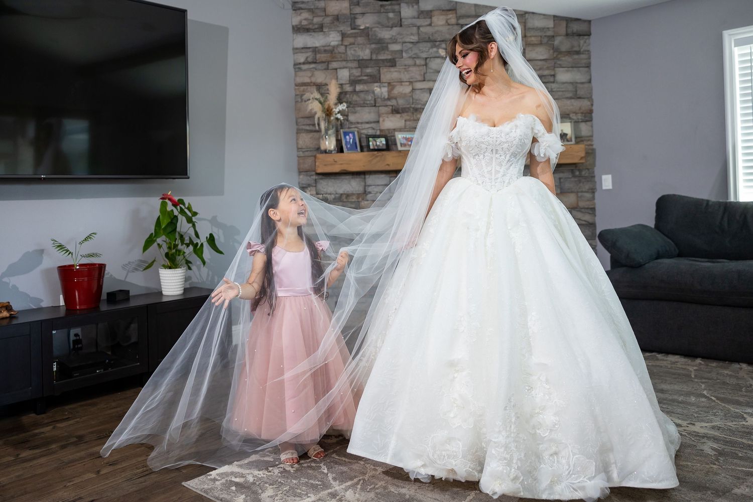 Wedding dress preparations showing elegant white gowns and pink tulle dresses in a modern living room setting.
