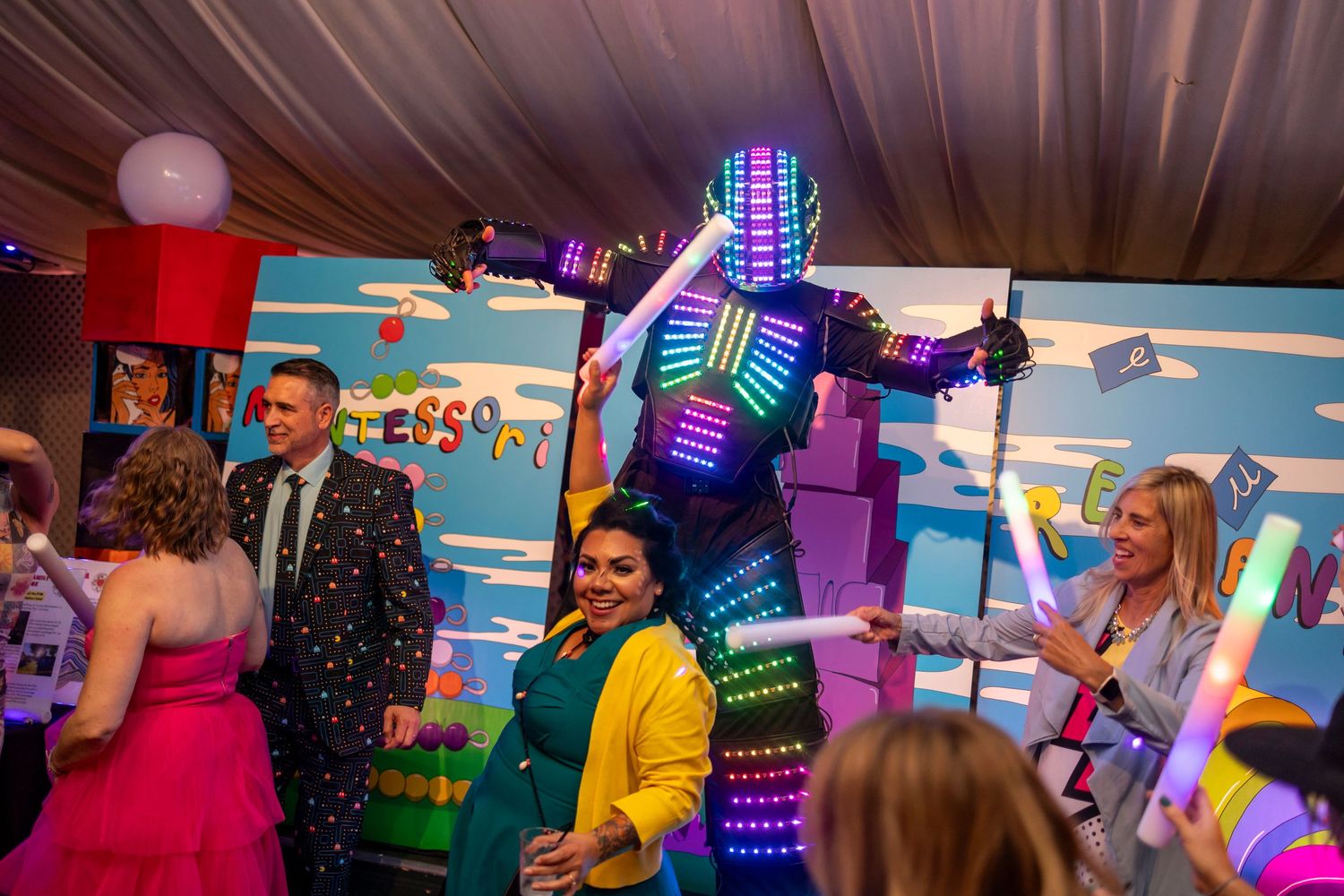 Event space decorated with neon lights and colorful decor elements during an evening gathering.