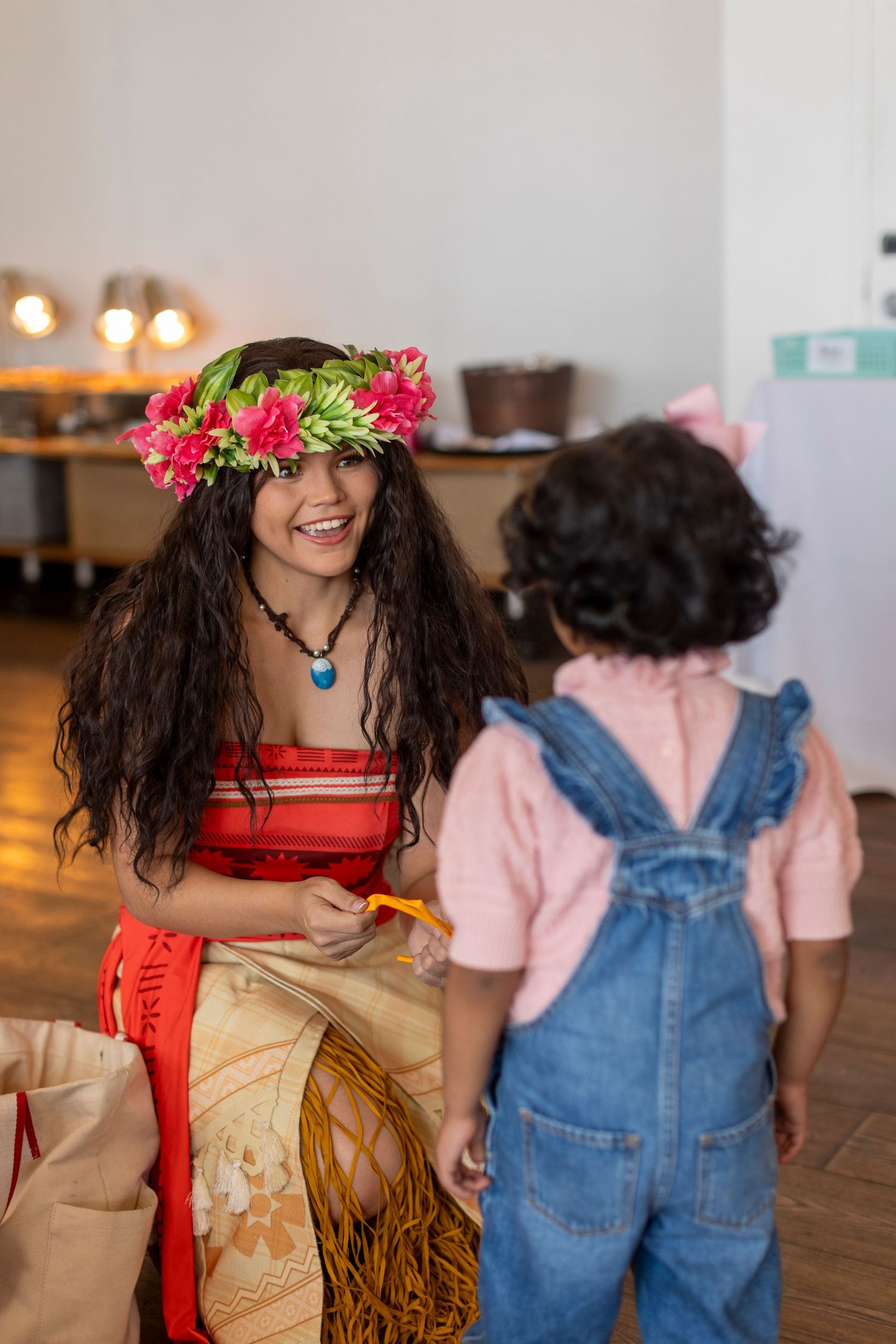 Party guests in themed costumes with floral headpieces dancing at an event in Huntington Beach.