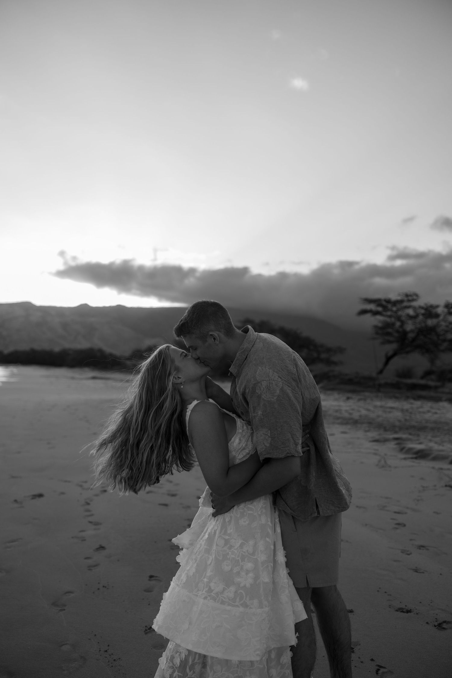 Silhouettes against a dusky beach landscape at sunset creating a romantic seaside moment.