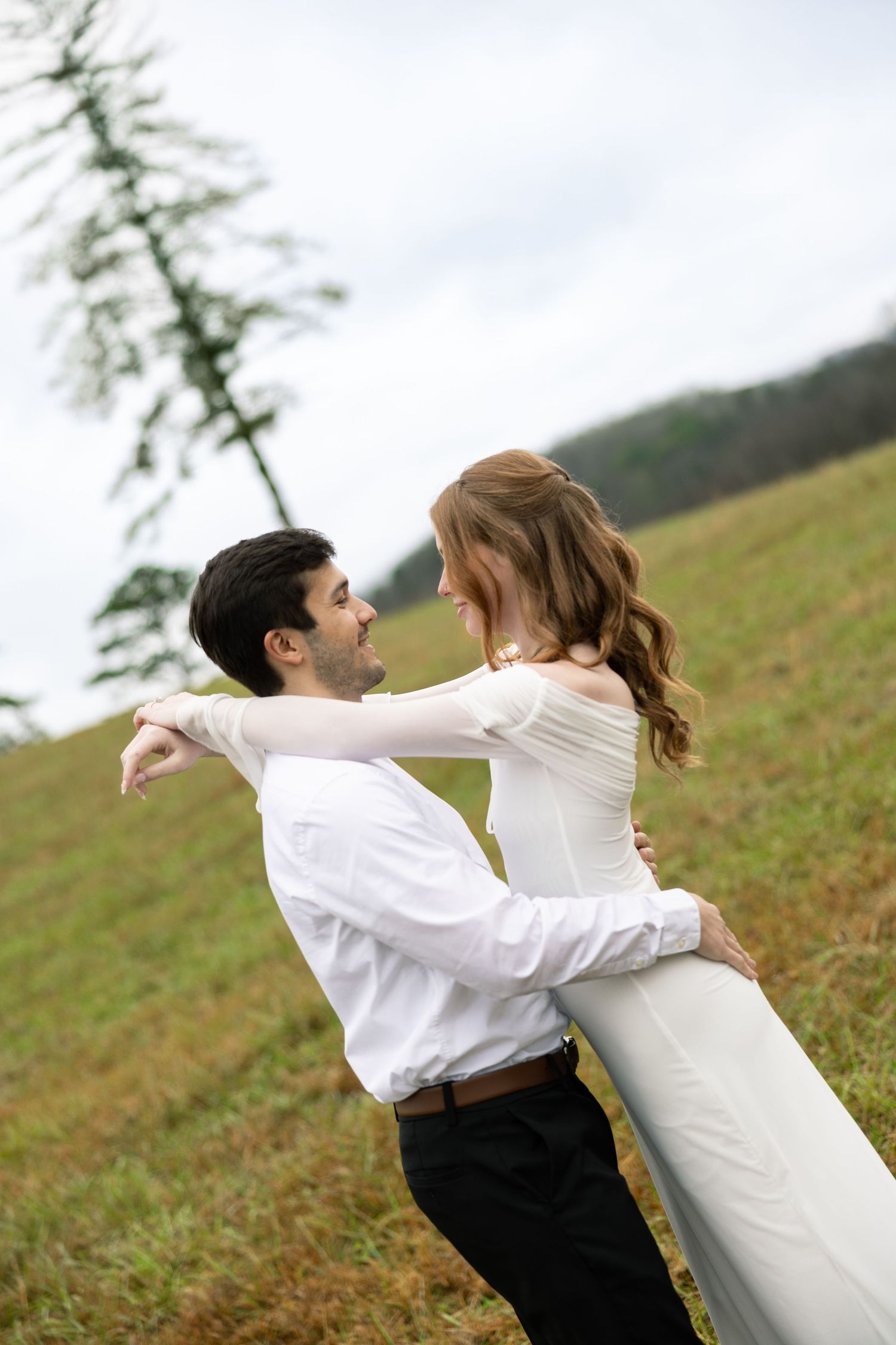 A couple in formal attire dances playfully in a grassy field, creating a series of romantic spinning movements.