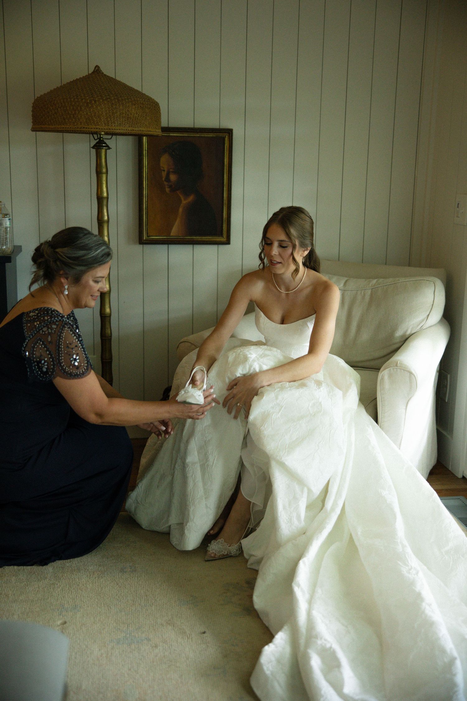 A bride in a white wedding dress sits on a white couch in a series of candid poses.