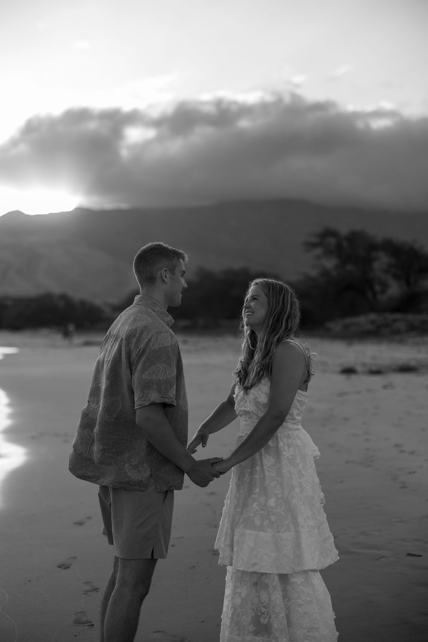A romantic black and white photo sequence shows a couple walking hand-in-hand along a beach at sunset.