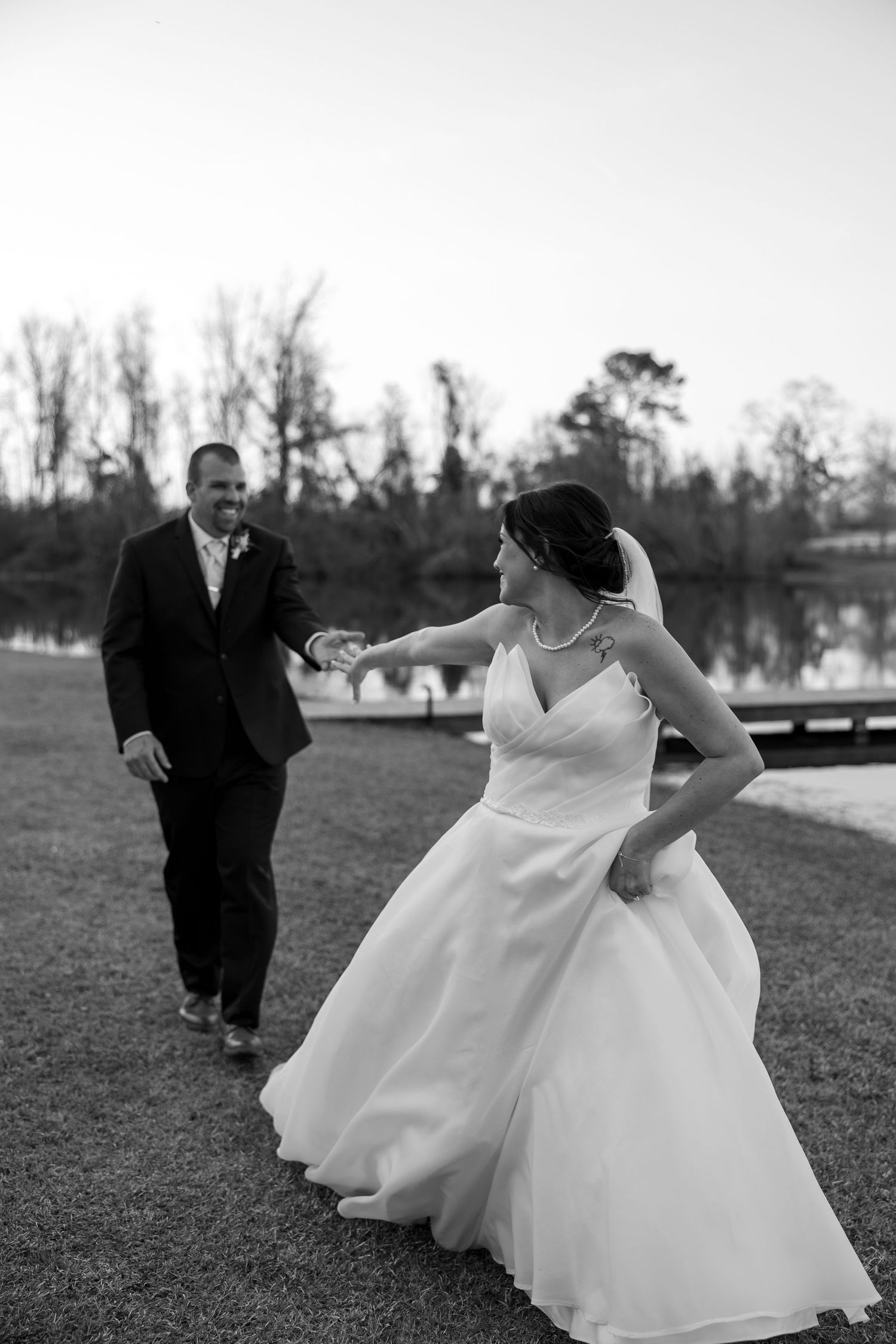 A joyful dance moment captured in black and white by a lakeside setting.