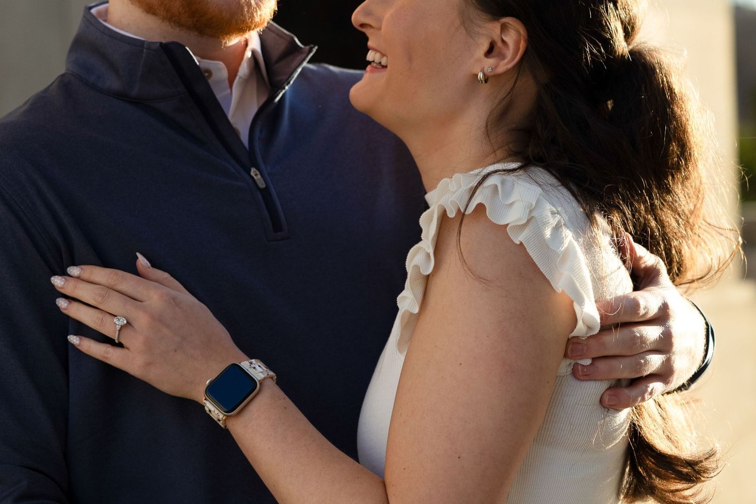 A couple in formal wedding attire shares an intimate moment during their outdoor photoshoot.