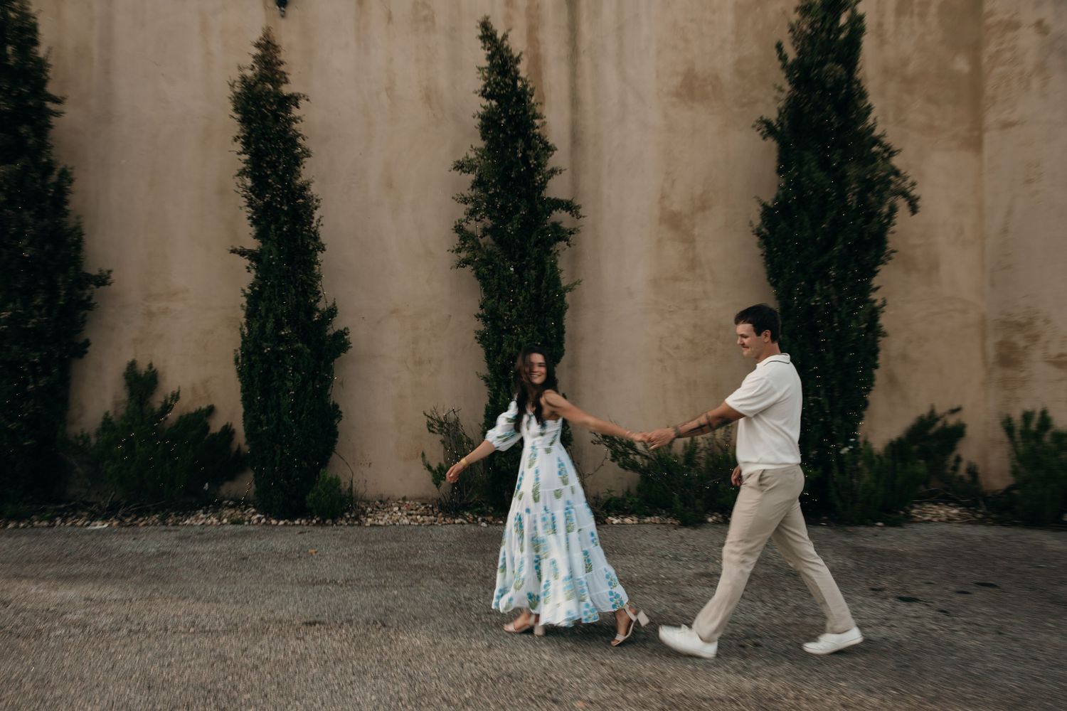 Minimalist wedding photo series showing couple's feet and legs walking against a concrete wall backdrop.