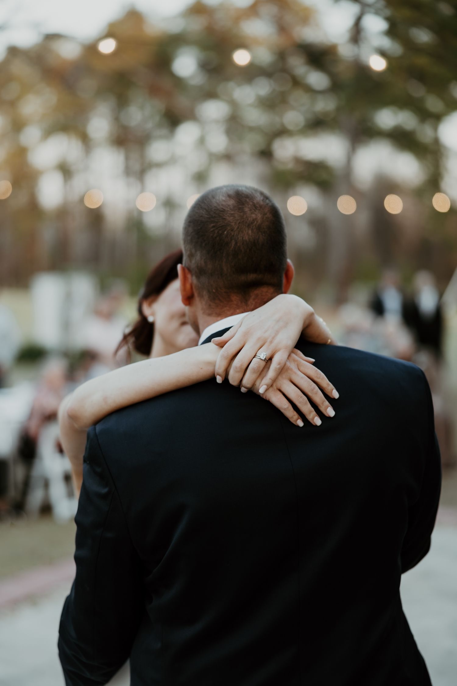 Emotional wedding moment captured in a series of four candid photos showing an intimate embrace with bokeh lighting.