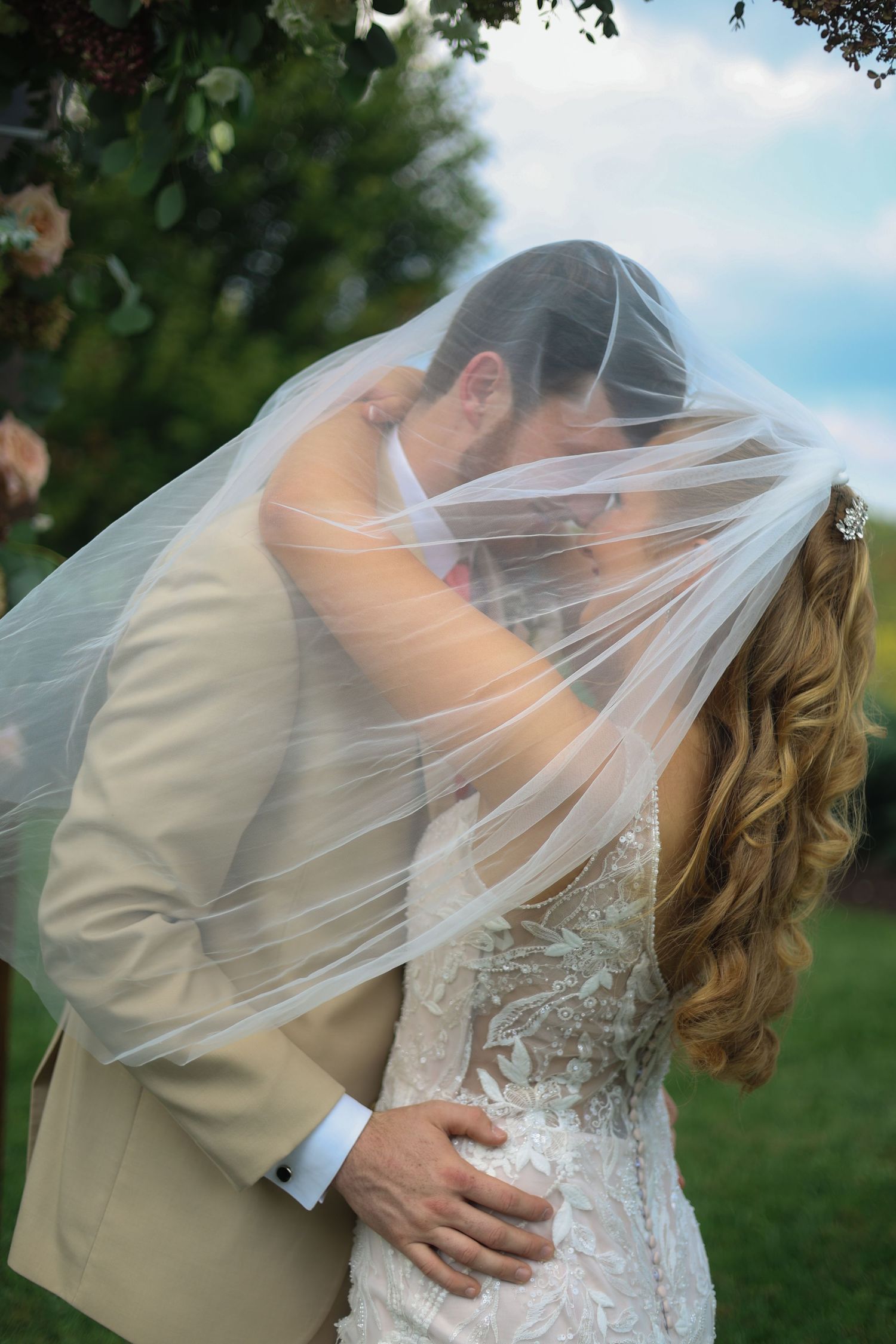 A romantic wedding sequence shows a couple kissing under a flowing white veil in an outdoor garden setting.