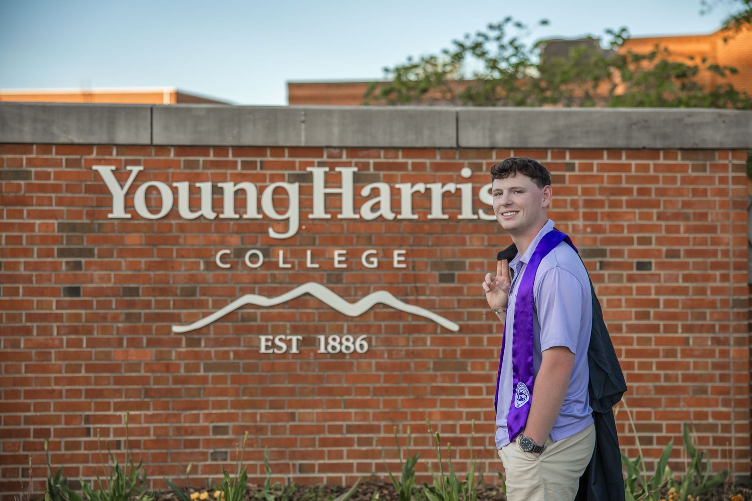 Sign for Young Harris College on a red brick wall with white lettering.