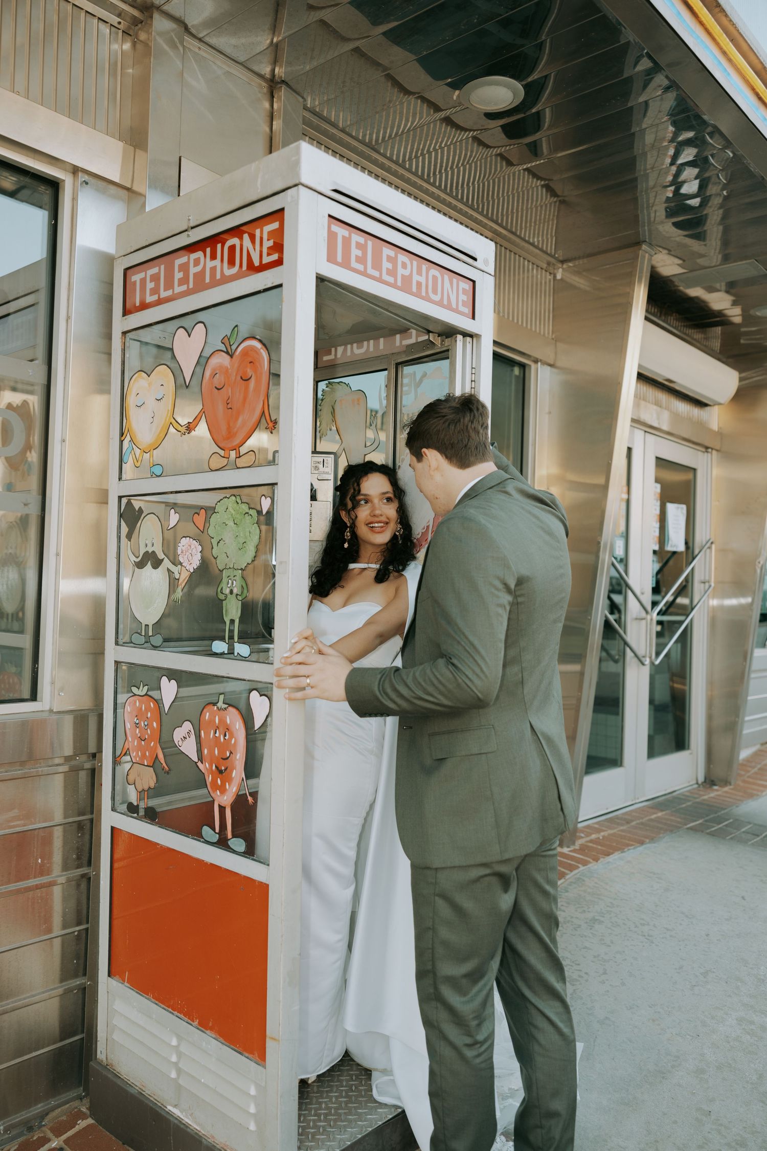A couple poses playfully in a series of vintage phone booth photos showing romantic and candid moments.