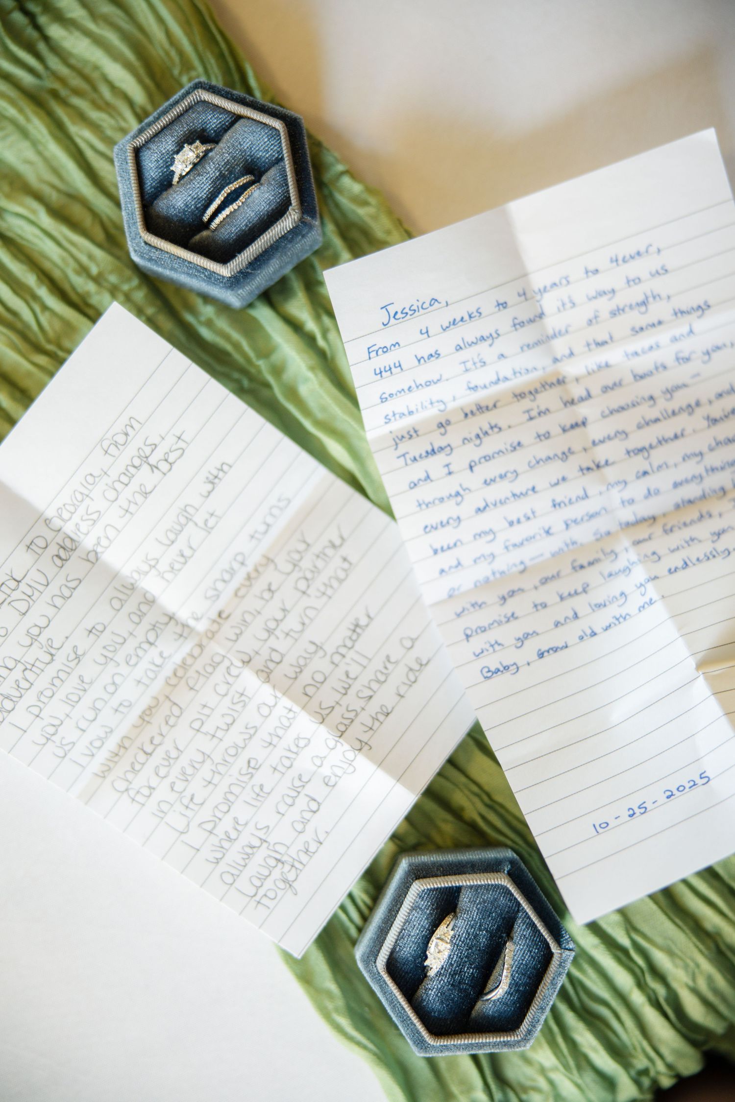 Handwritten notes scattered on a green textured surface with small hexagonal boxes containing jewelry items.