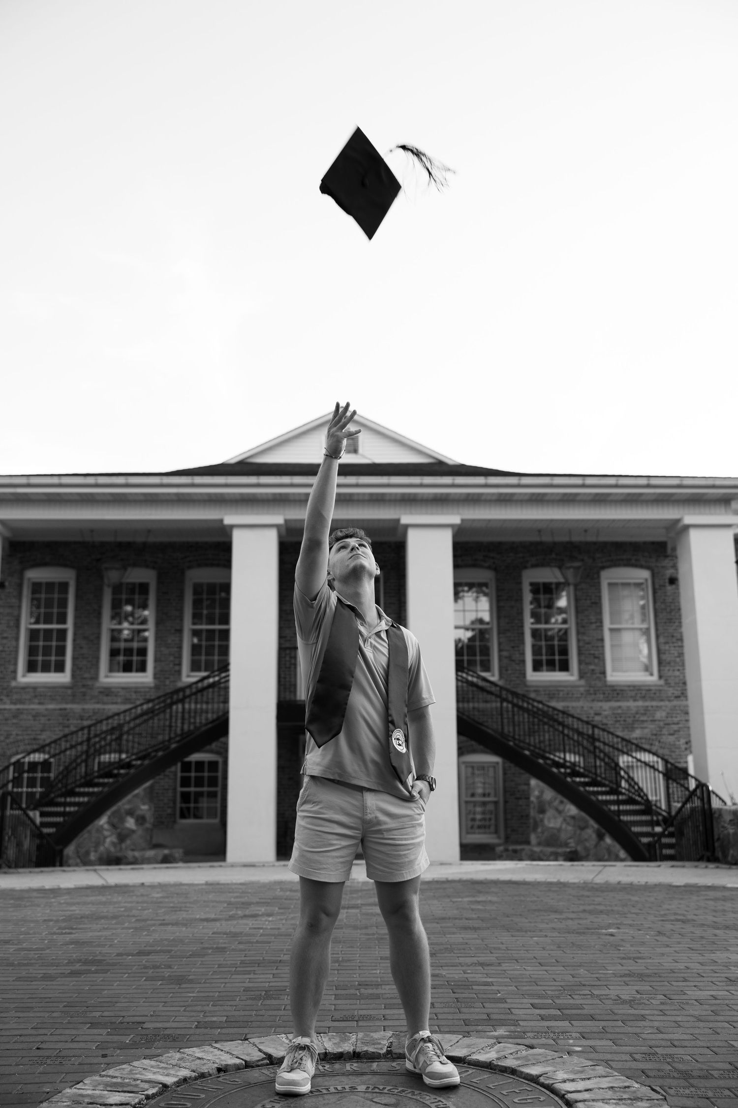 Black and white graduation photos showing a brick building with curved staircases.