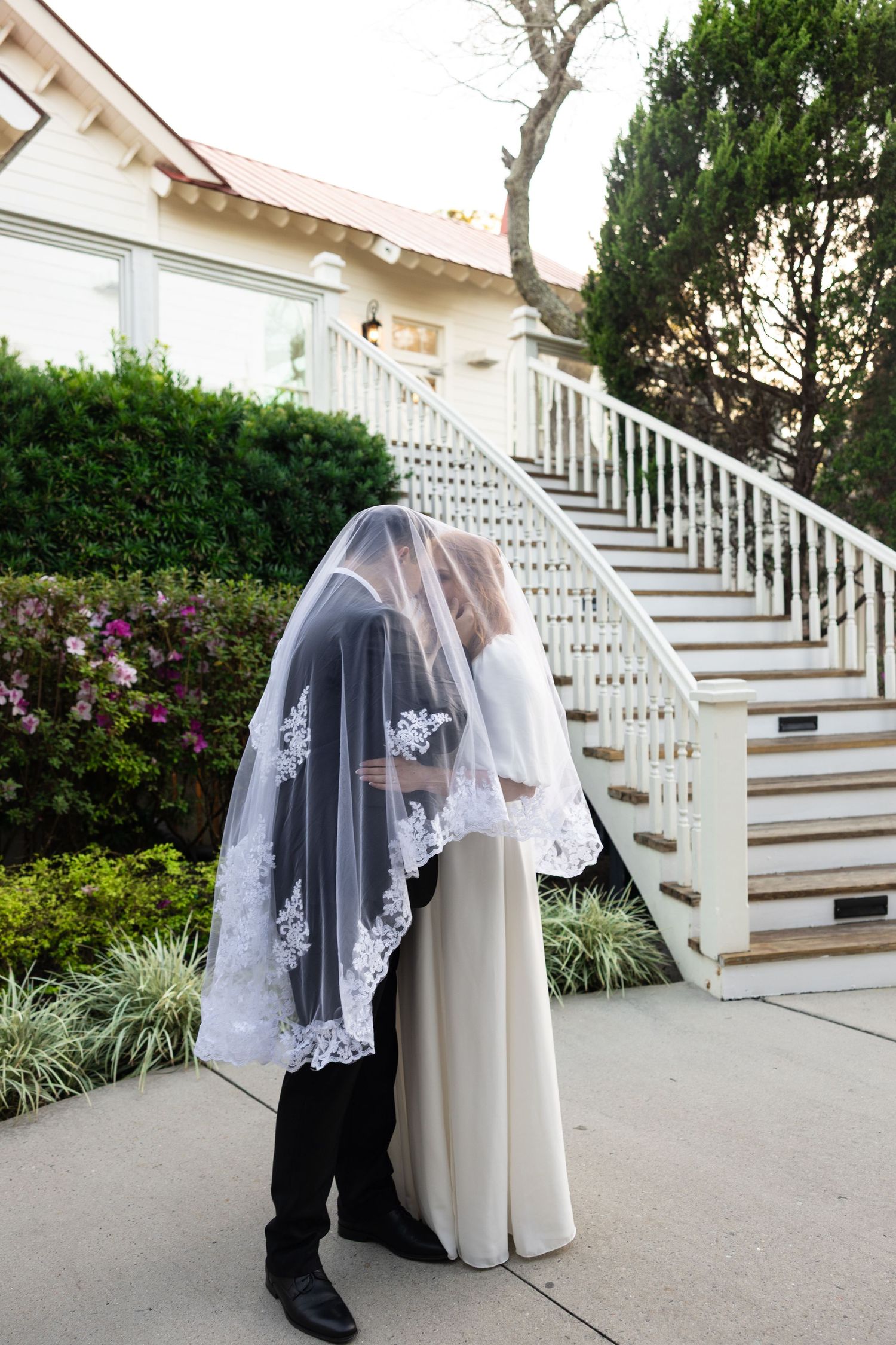 A series of wedding dress photos showing a white gown and veil against outdoor stairs and garden landscaping.