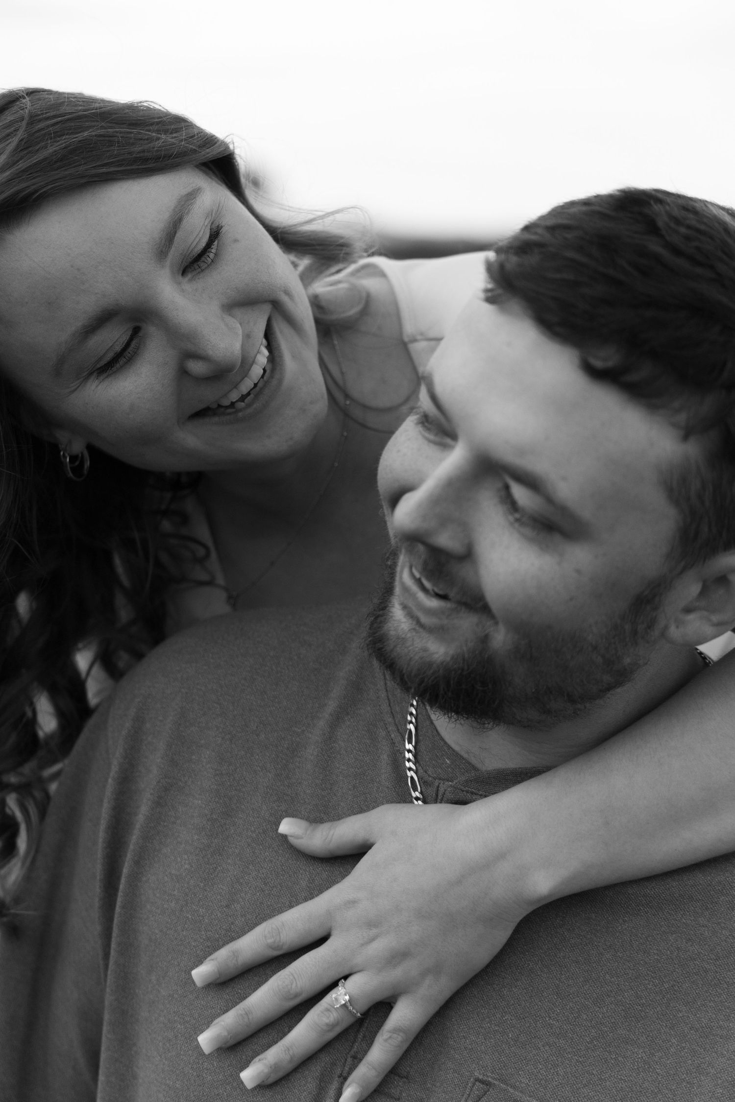 Black and white photos showing affectionate moments between a couple embracing.