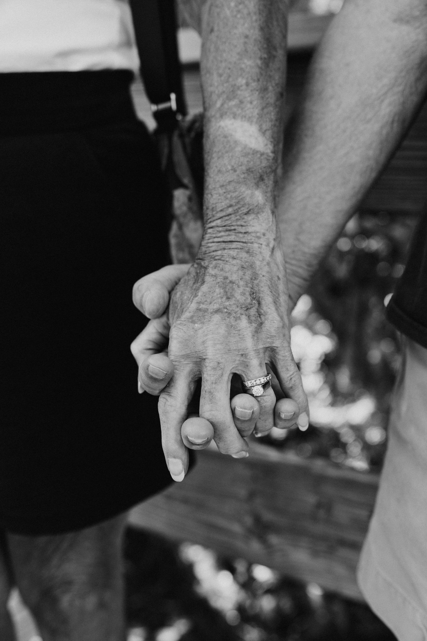 Close-up black and white shots of hands tenderly intertwined.