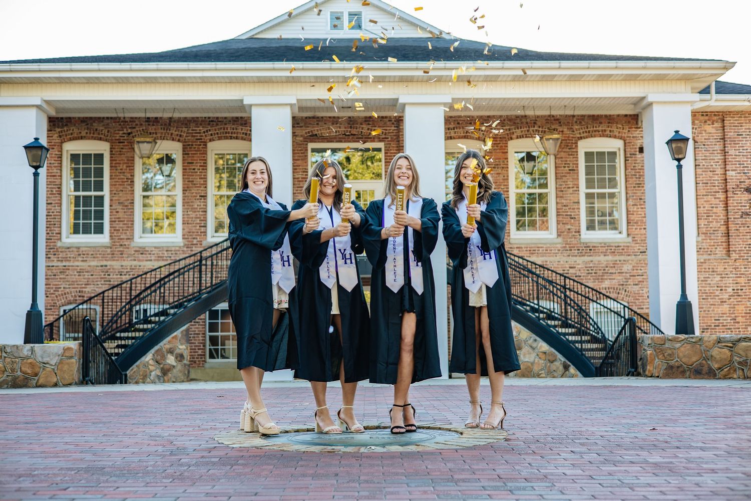 Brick building with white columns and symmetrical architecture captured in a sequence of graduation photos.