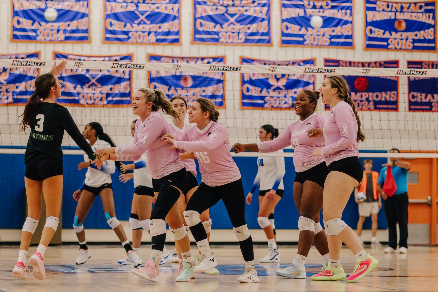 Volleyball team celebrating after exciting point.