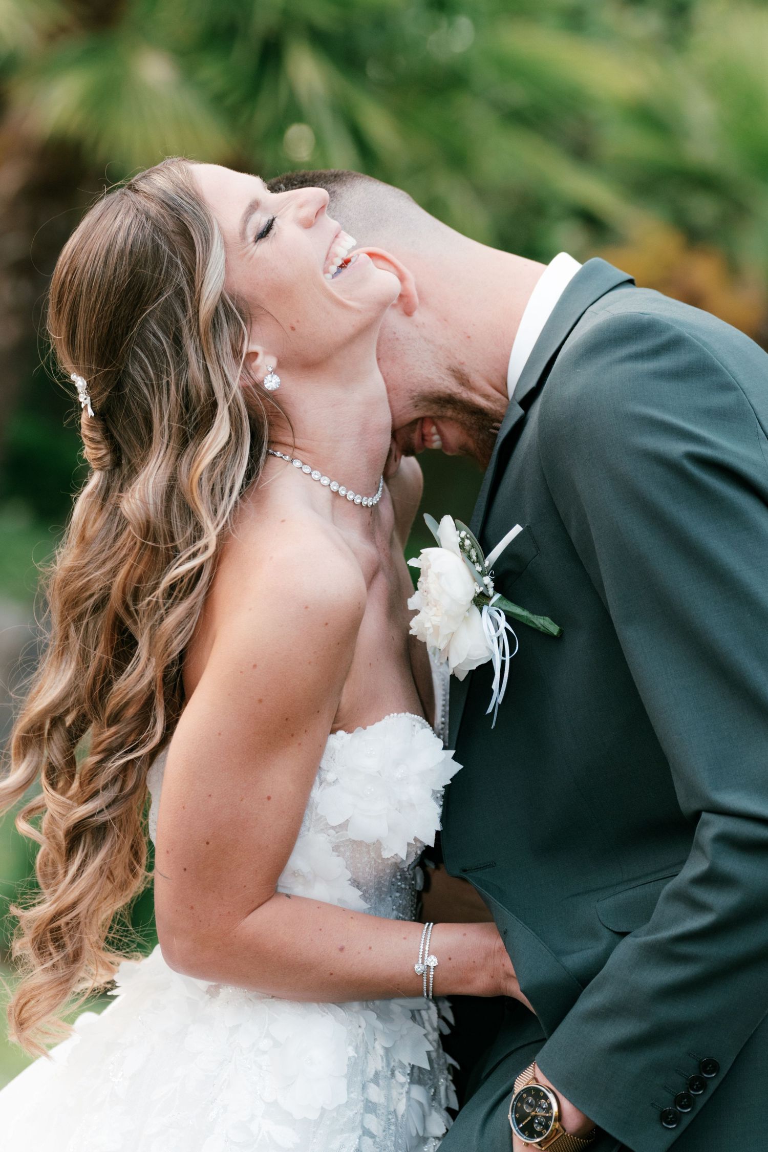 Bride laughs joyfully as groom nuzzles her neck in outdoor wedding portrait. Mallorca wedding photographer and filmmaker.